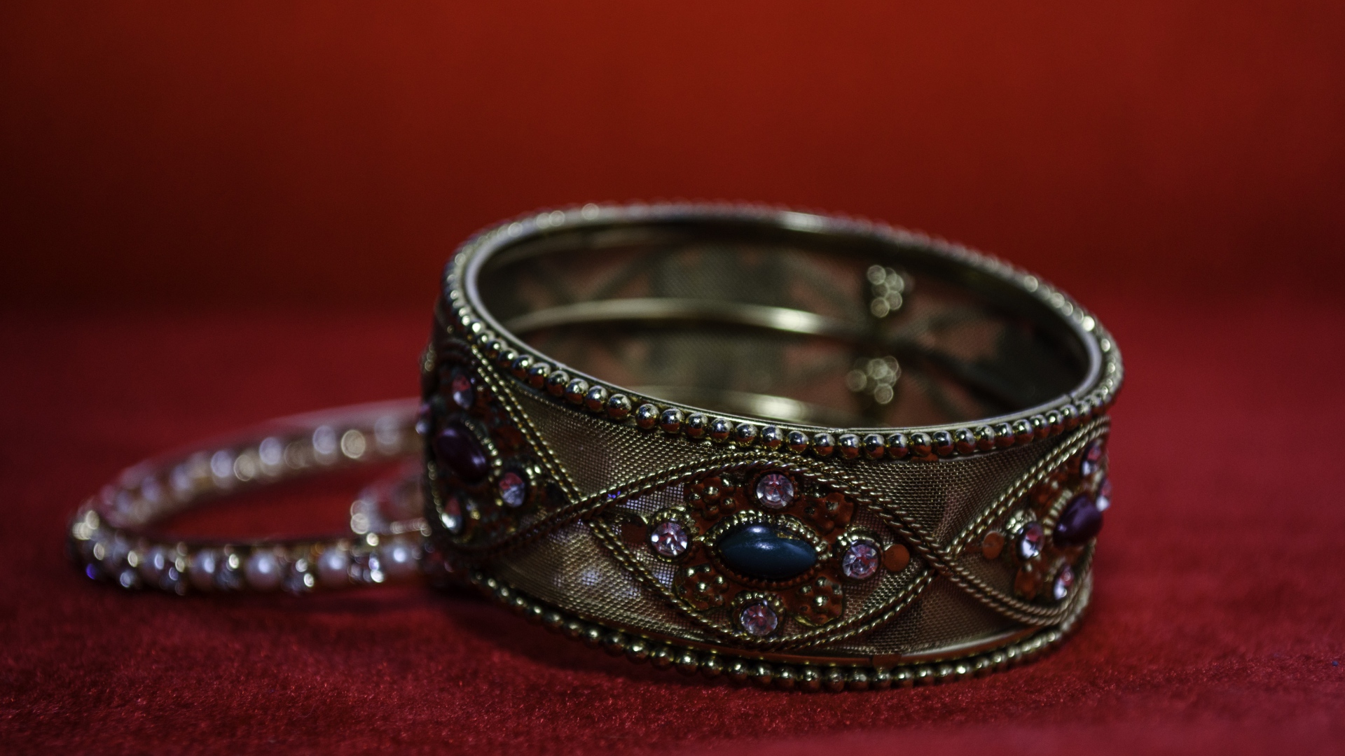 Красивый браслет с драгоценными камнями на красном фоне 