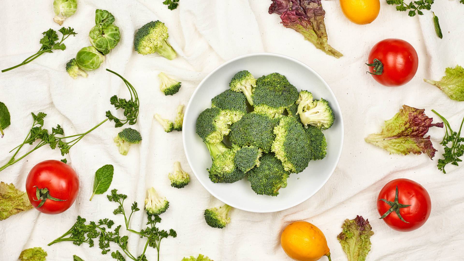 Брокколи на столе с помидорами и зеленью