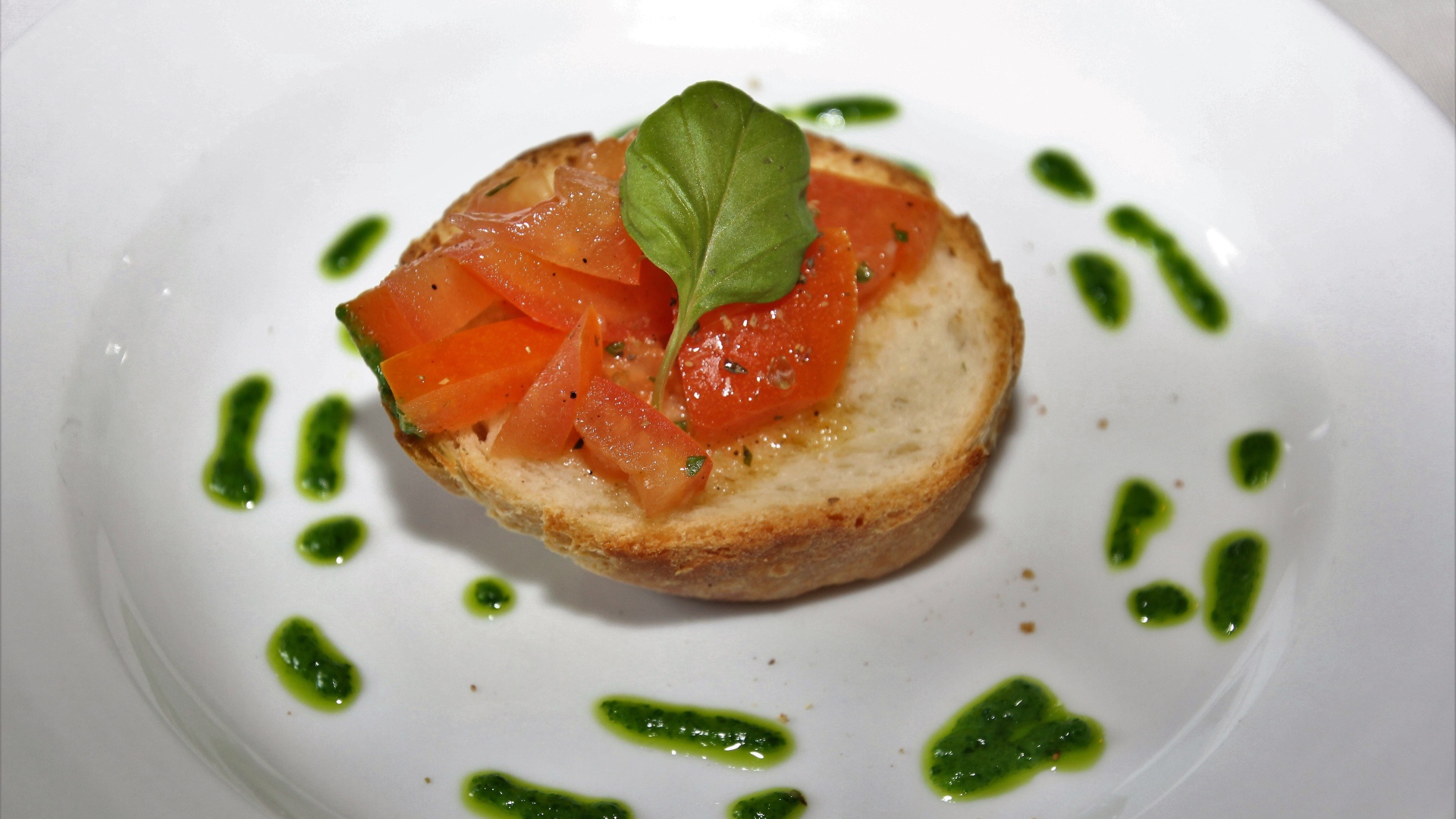 Брускетта на тарелке с помидорами и соусом