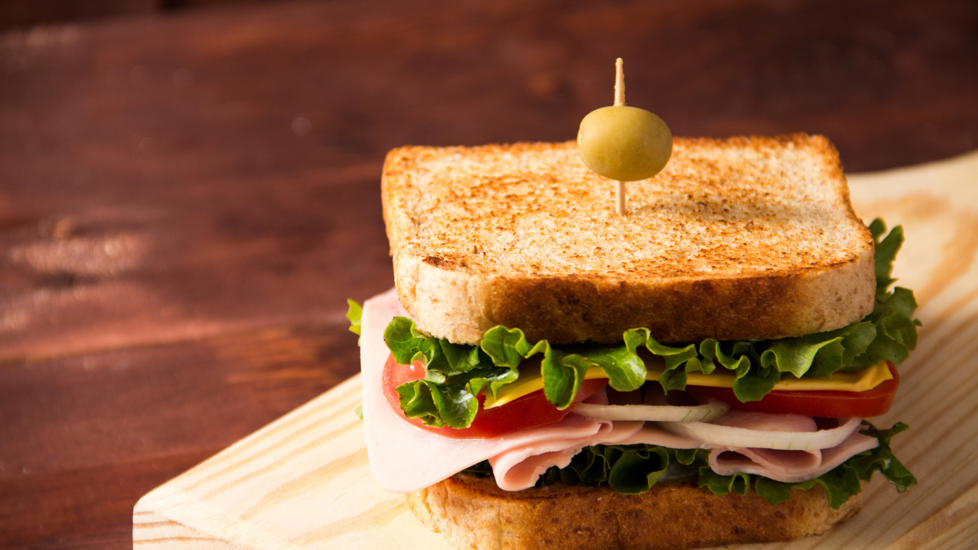 Гамбургер с ветчиной, помидорами, листьями салата и сыром