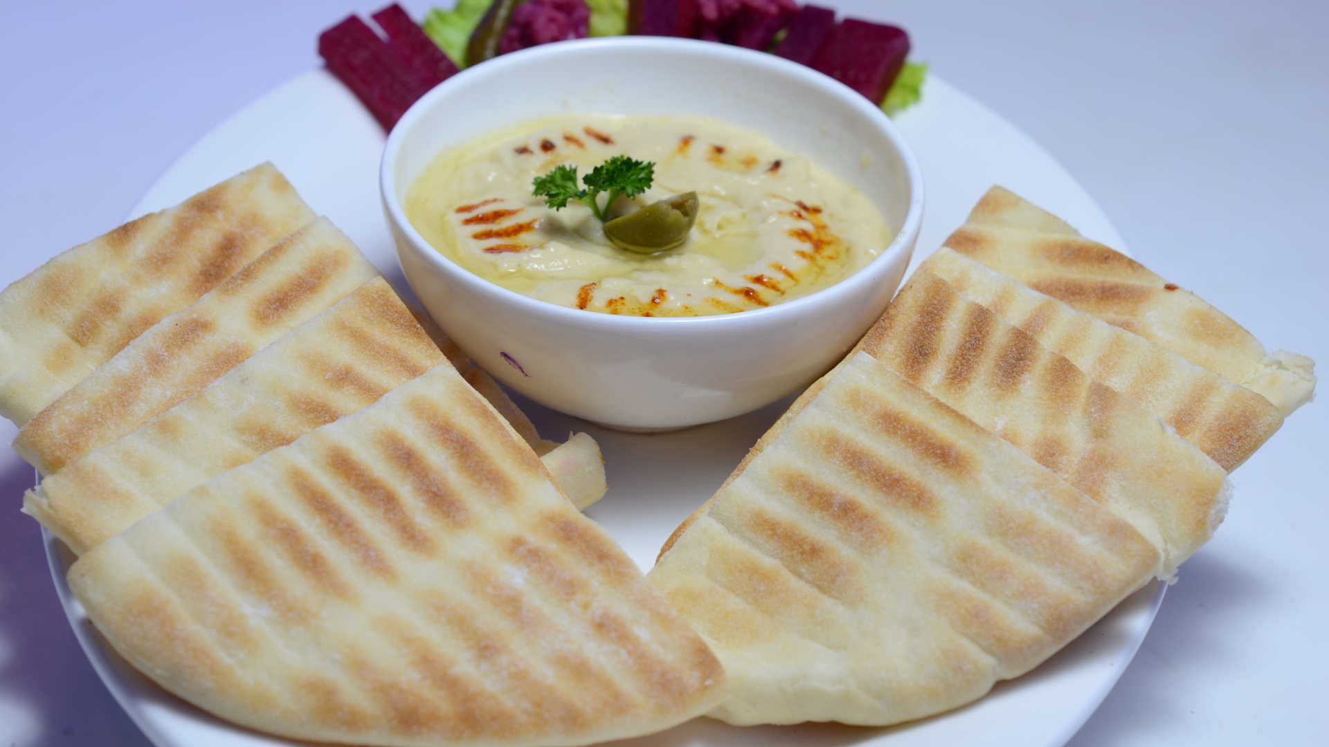 Хумус в белой тарелке с лавашом