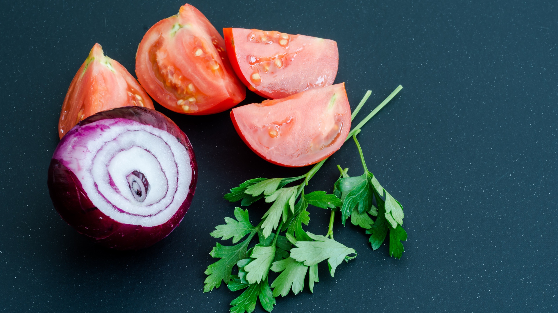 Лук, помидоры и петрушка на сером столе