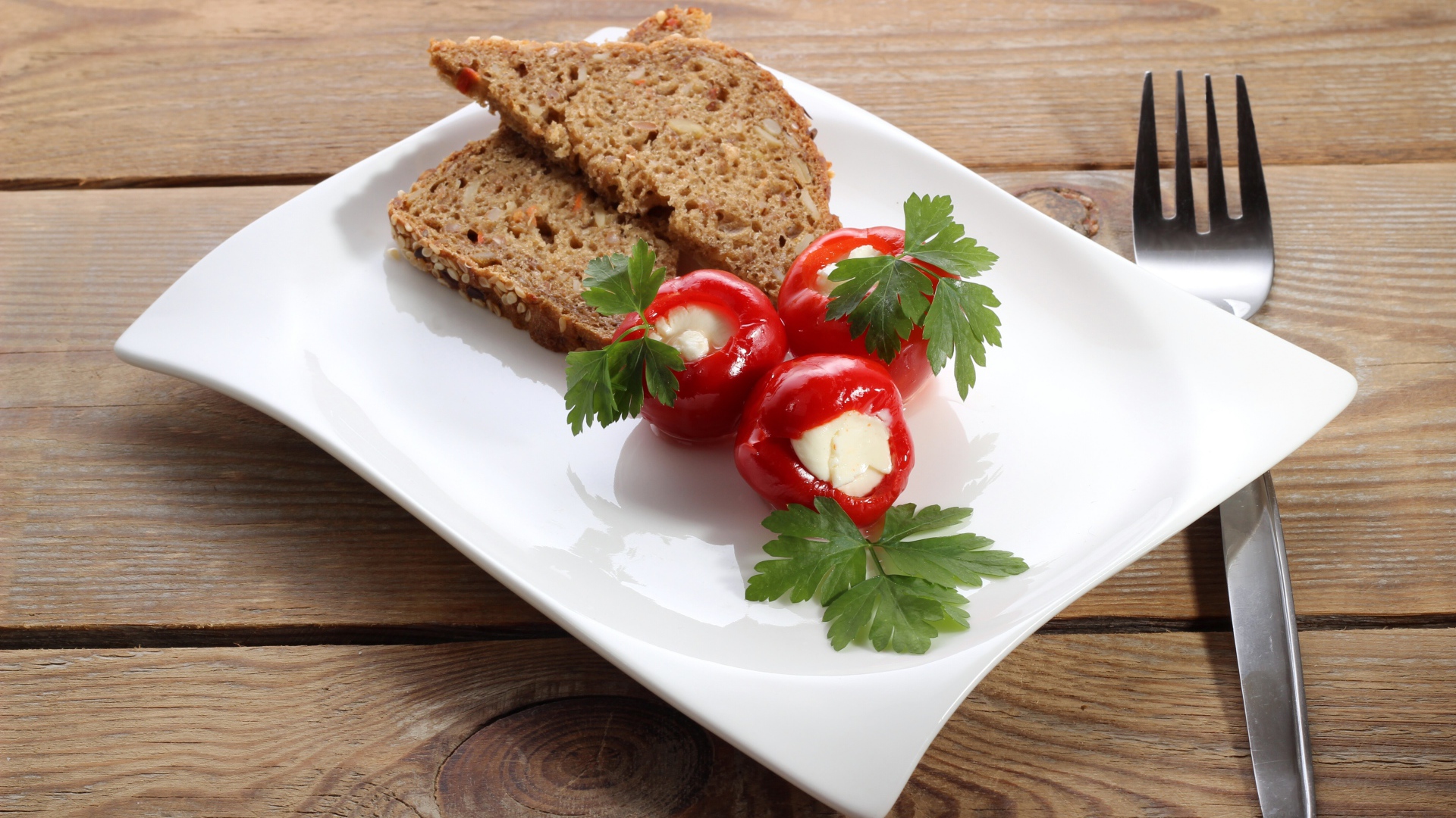 Фаршированный перец на большой белой тарелке с хлебом