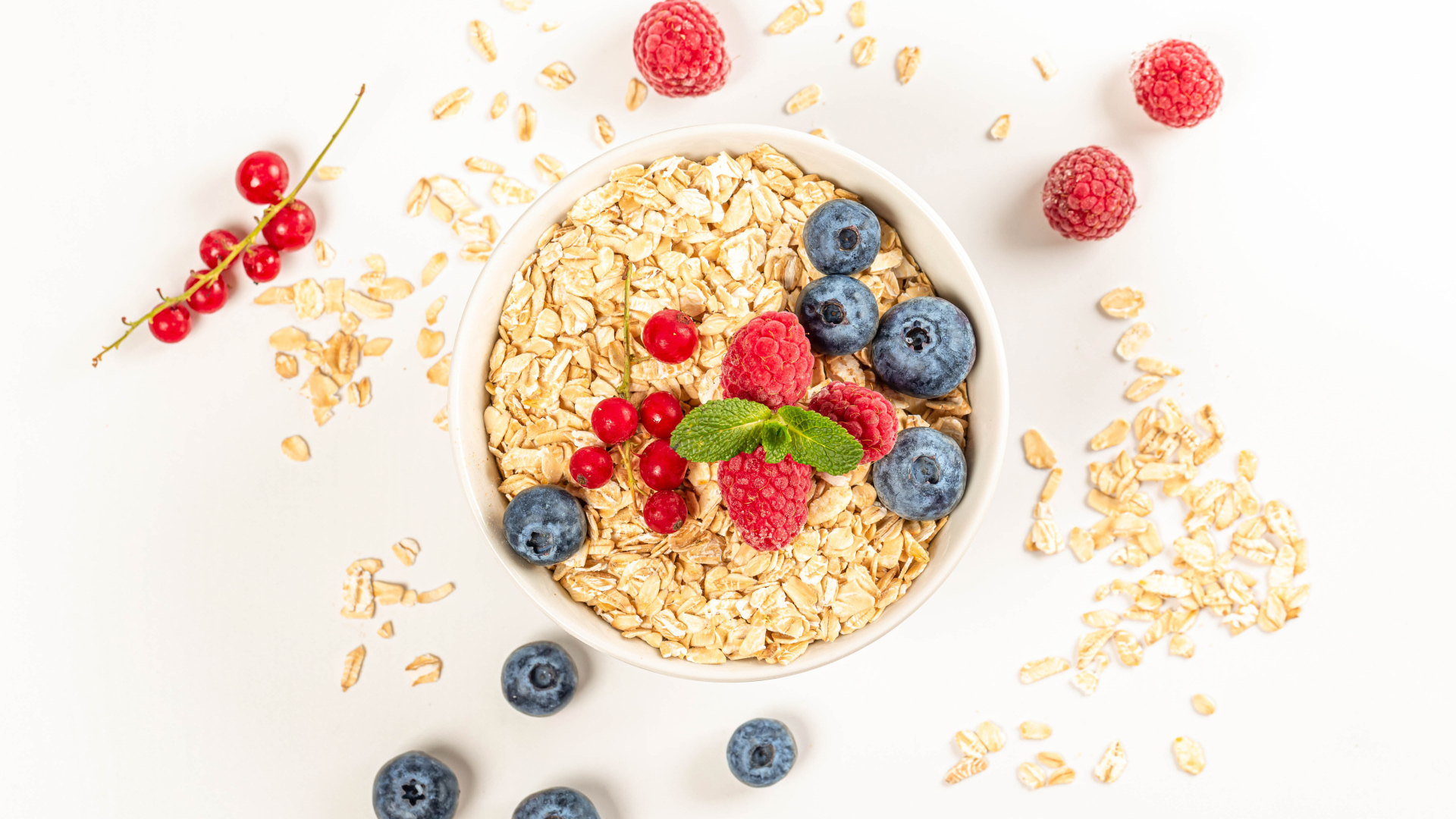 Овсяные хлопья с ягодами черники и малины на белом фоне 