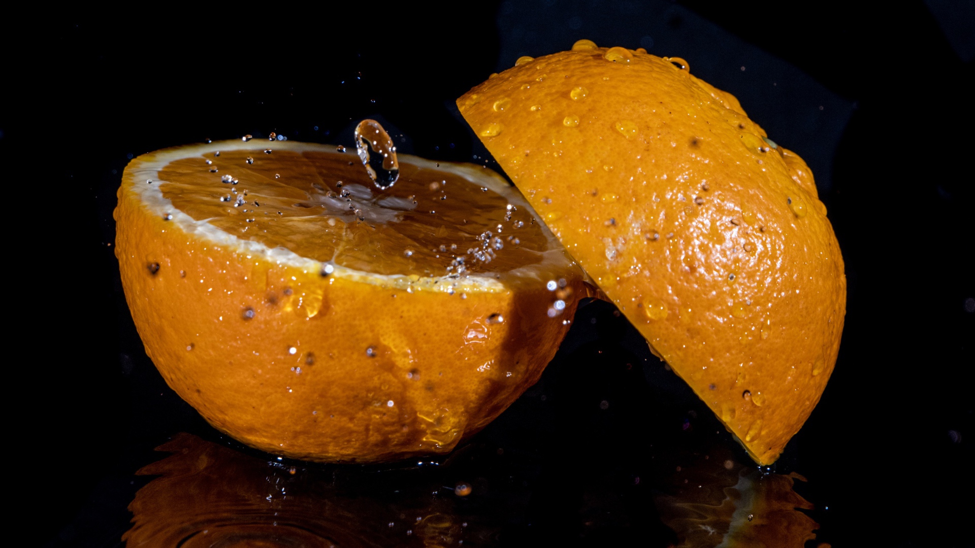 Две половины апельсина на черном фоне 