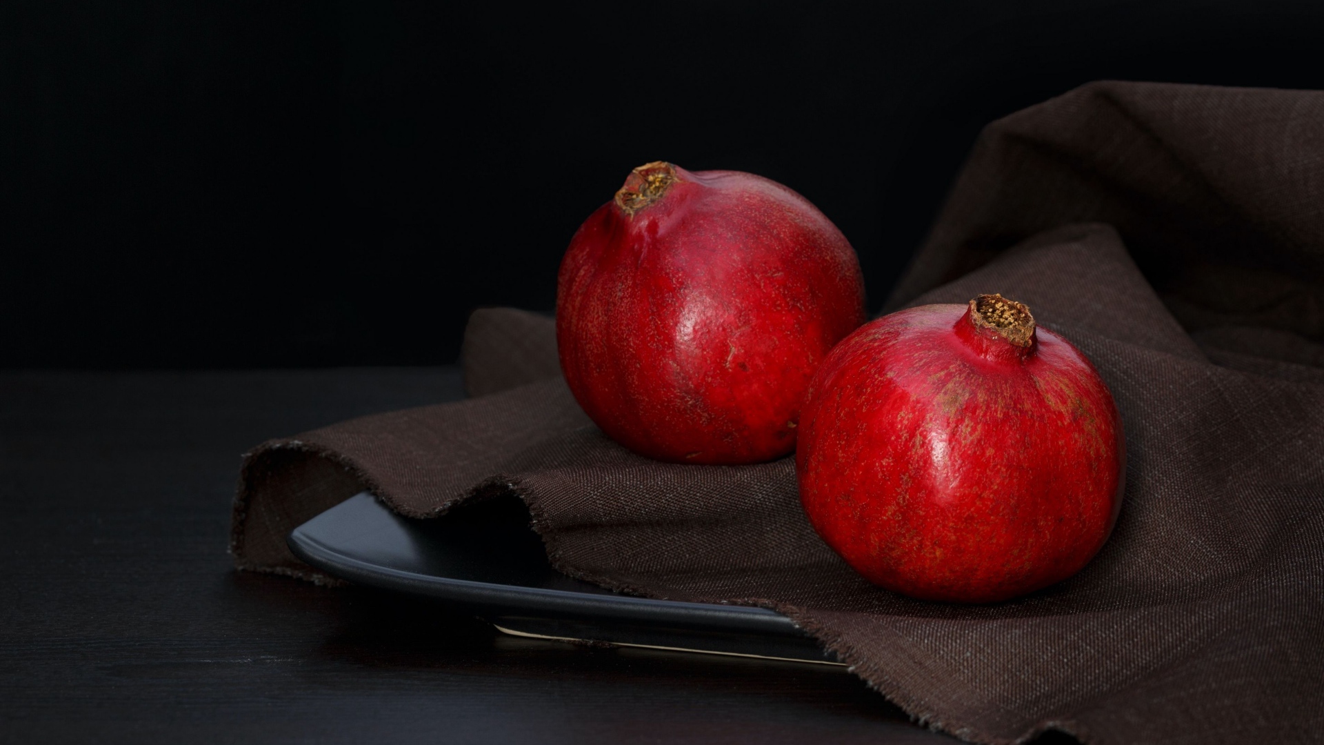Два красных граната на столе