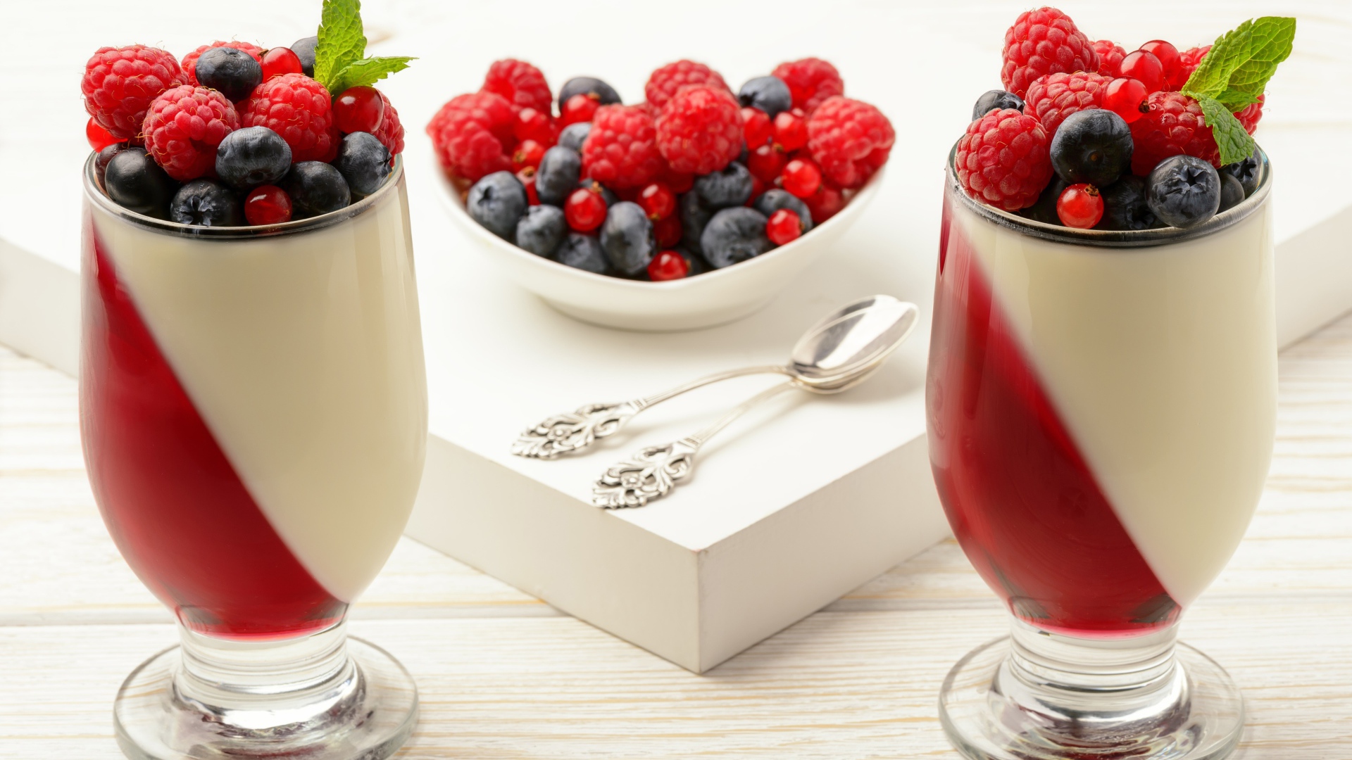 Двухцветный десерт с ягодами на столе 