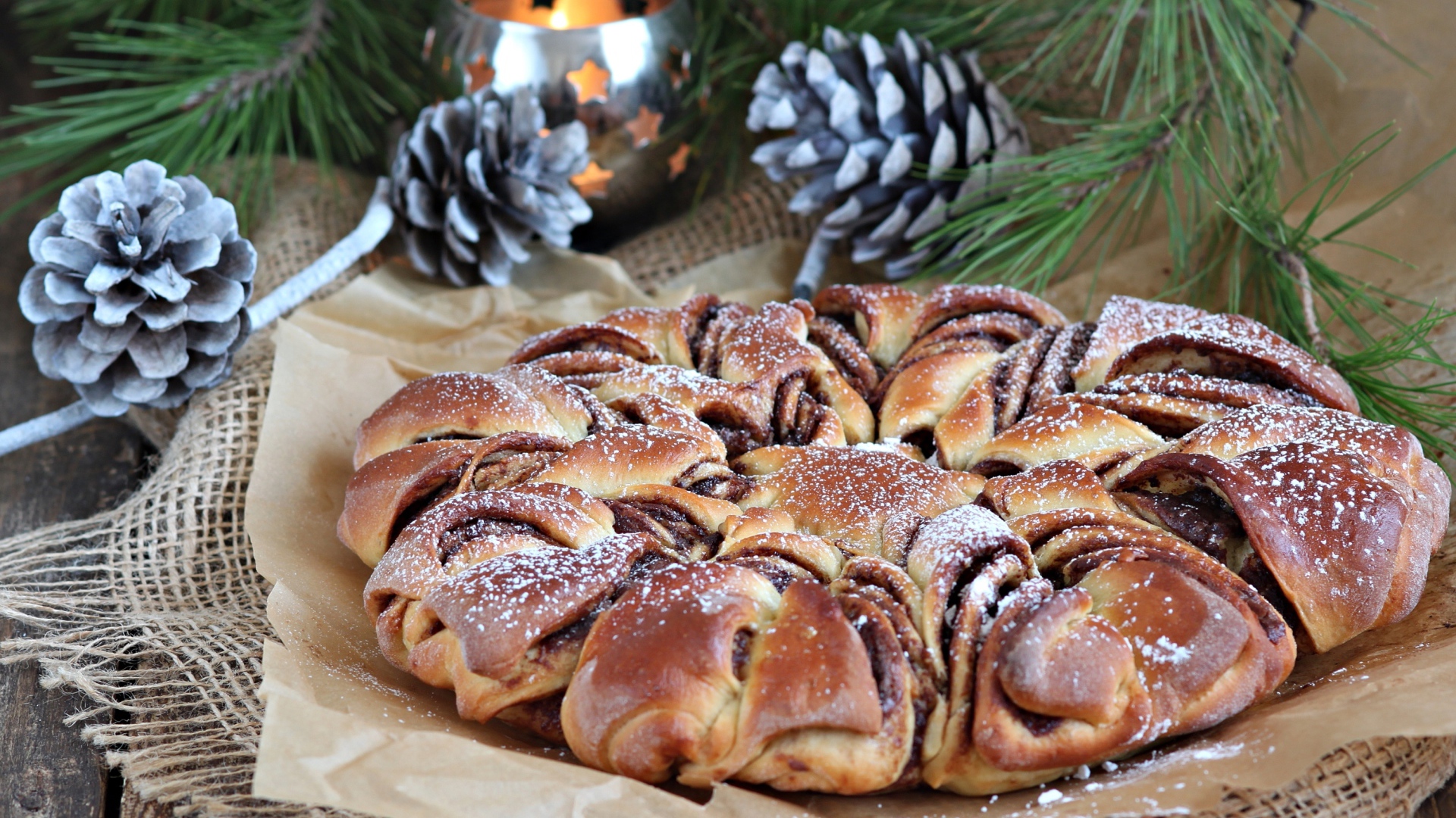 Сдобный венок с вареньем на столе с шишками