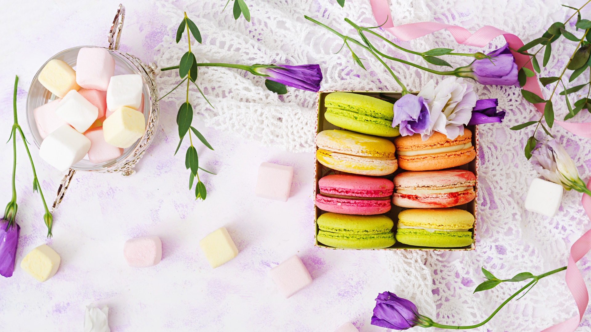 Десерт макарон на столе с кружевной салфеткой и маршмеллоу