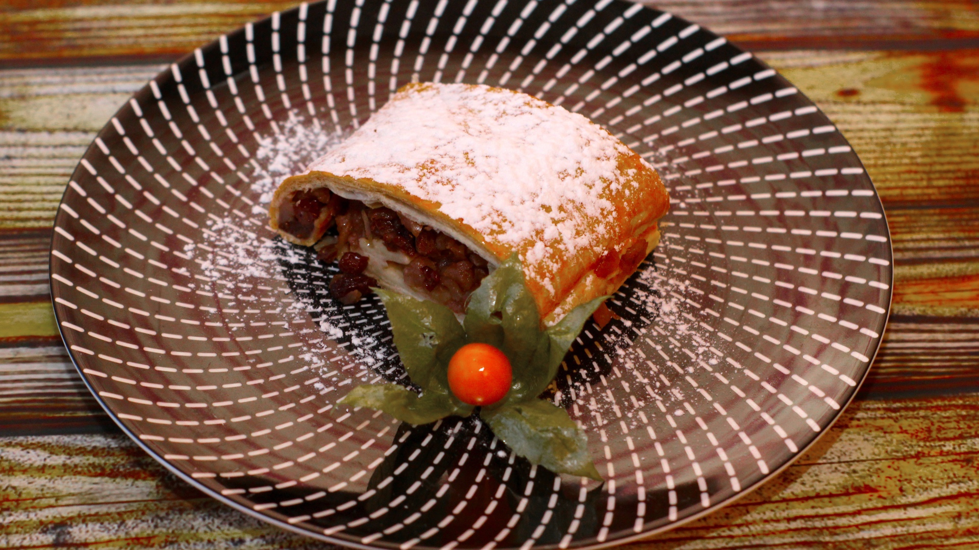 Кусок яблочного штруделя на тарелке 