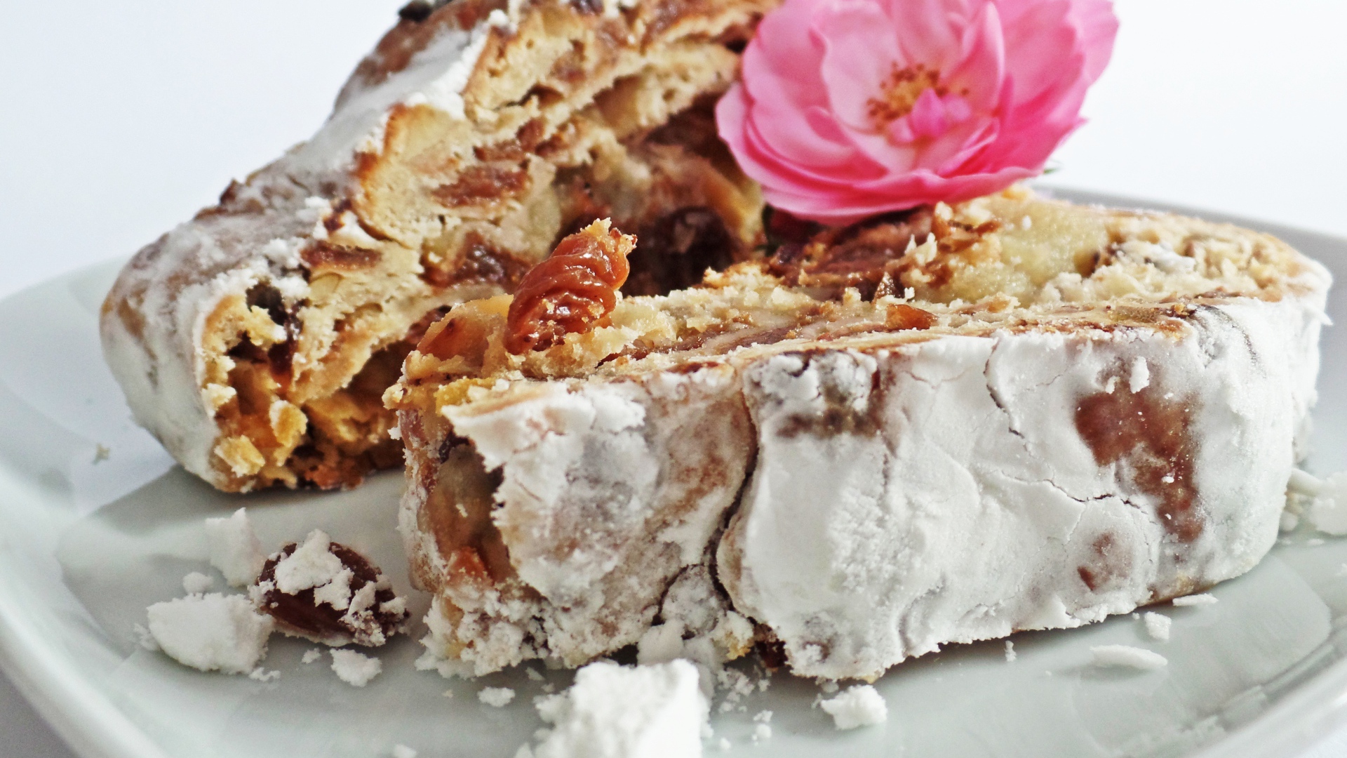 Кусок пирога на белой тарелке с цветком розы 