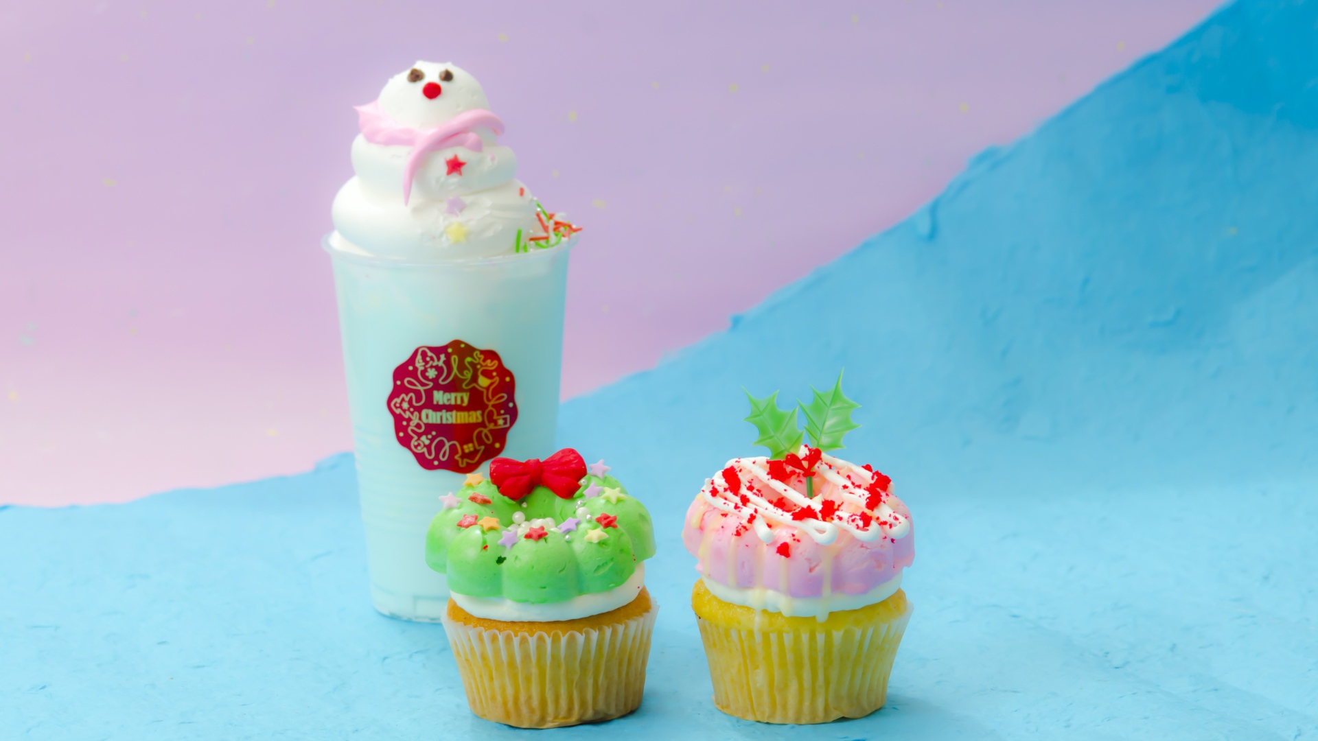 Two cupcakes and a cocktail on a bright background