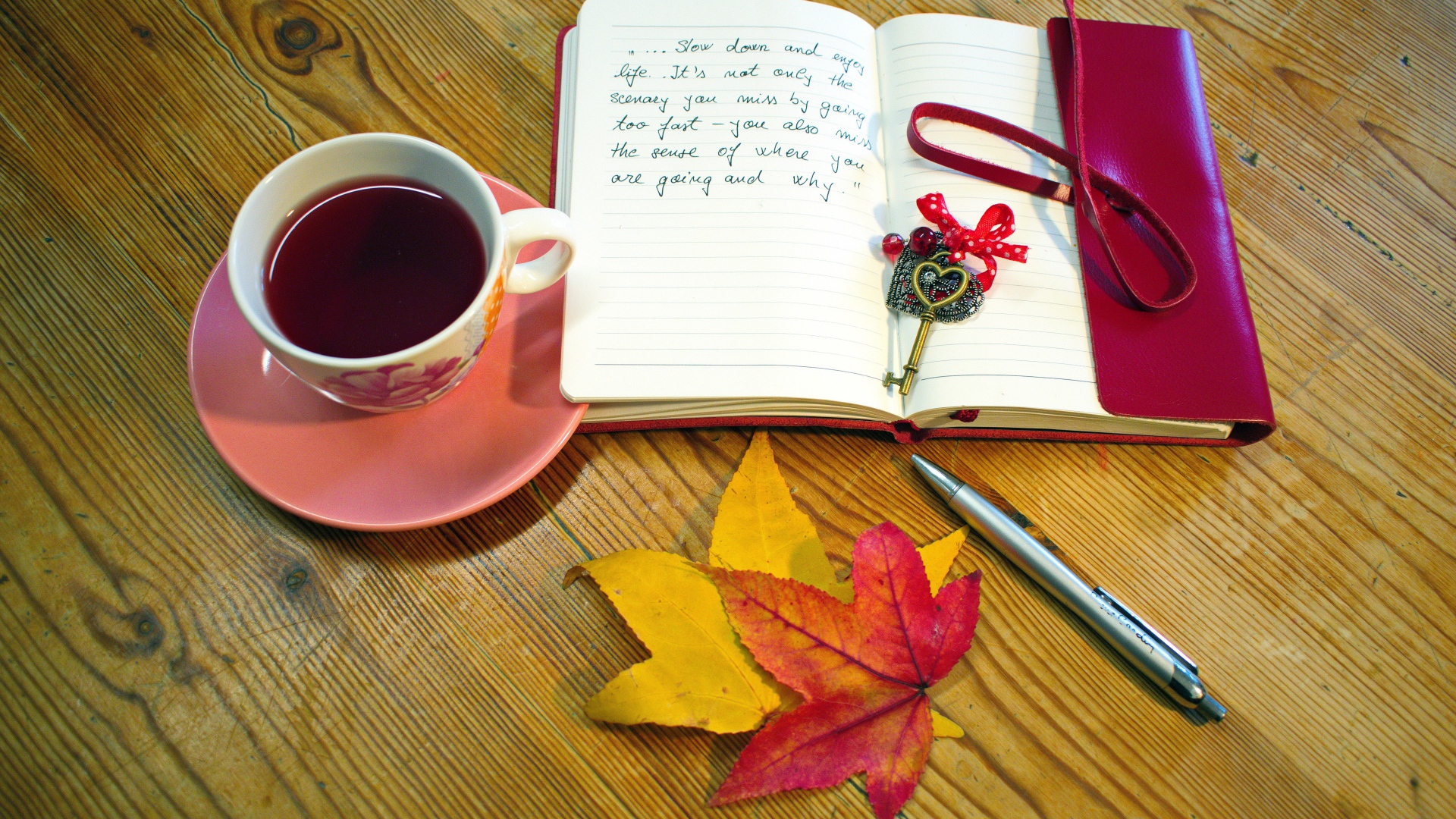 Чашка чая с блокнотом и листьями на столе 