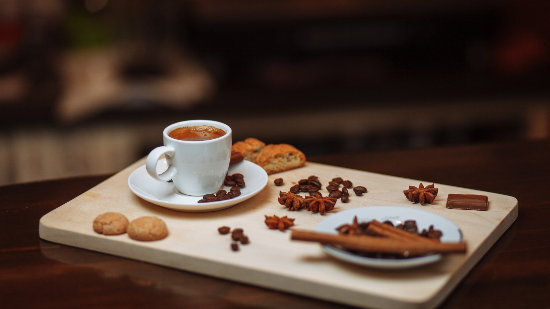 Маленькая чашка кофе на столе с корицей, бадьяном и печеньем 