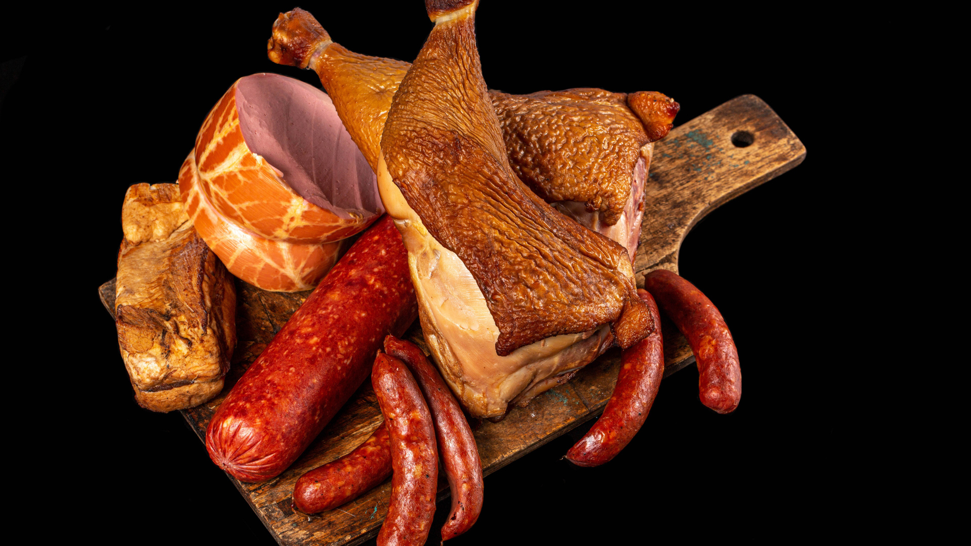 Appetizing smoked meats and sausage on a black background