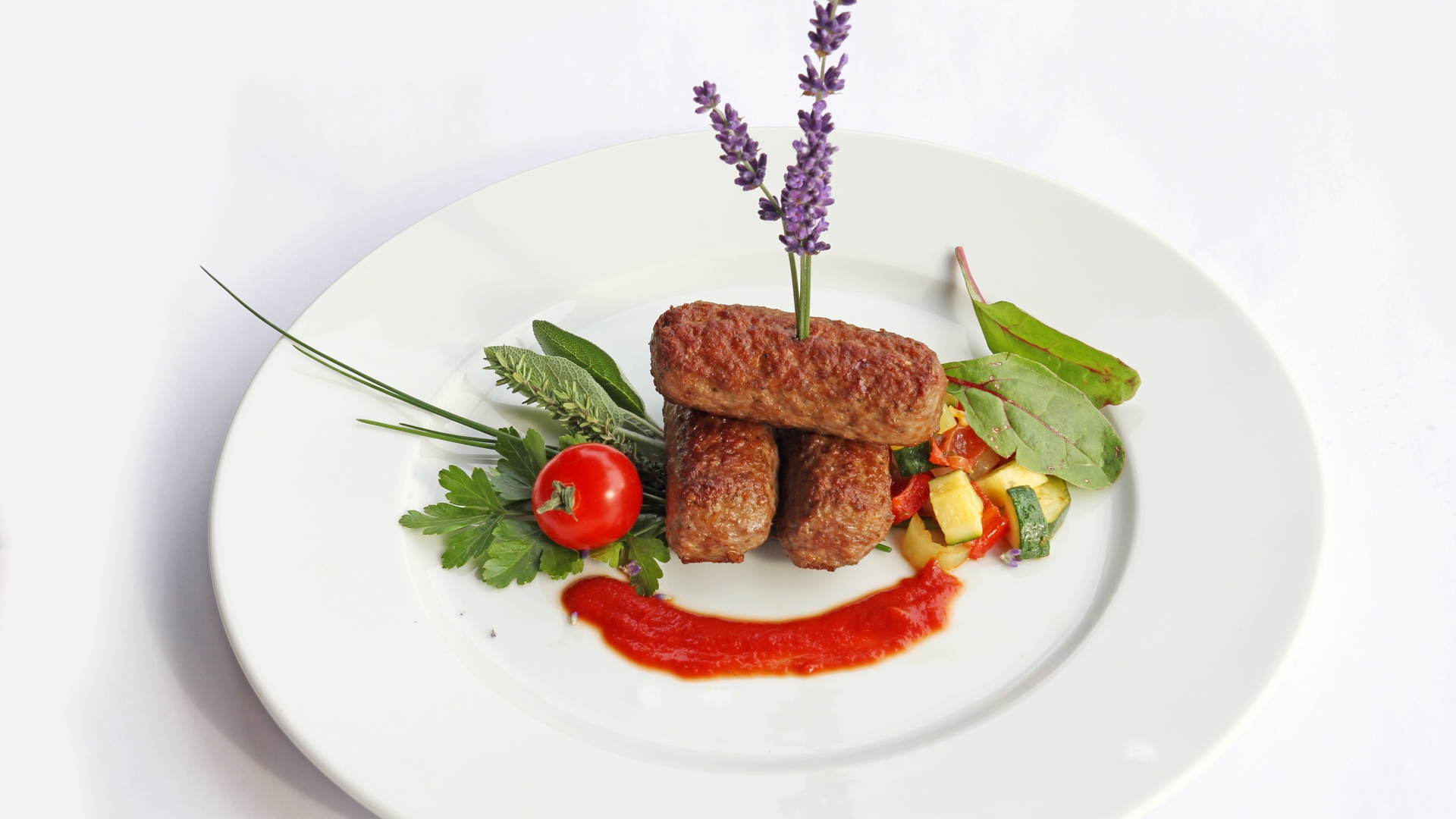 Meat sticks on a plate with herbs and sauce