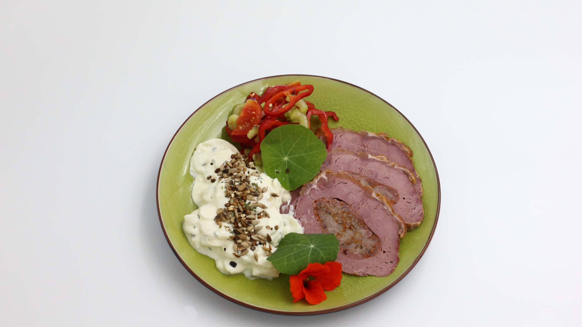 Мясо с соусом и овощами на тарелке на сером фоне