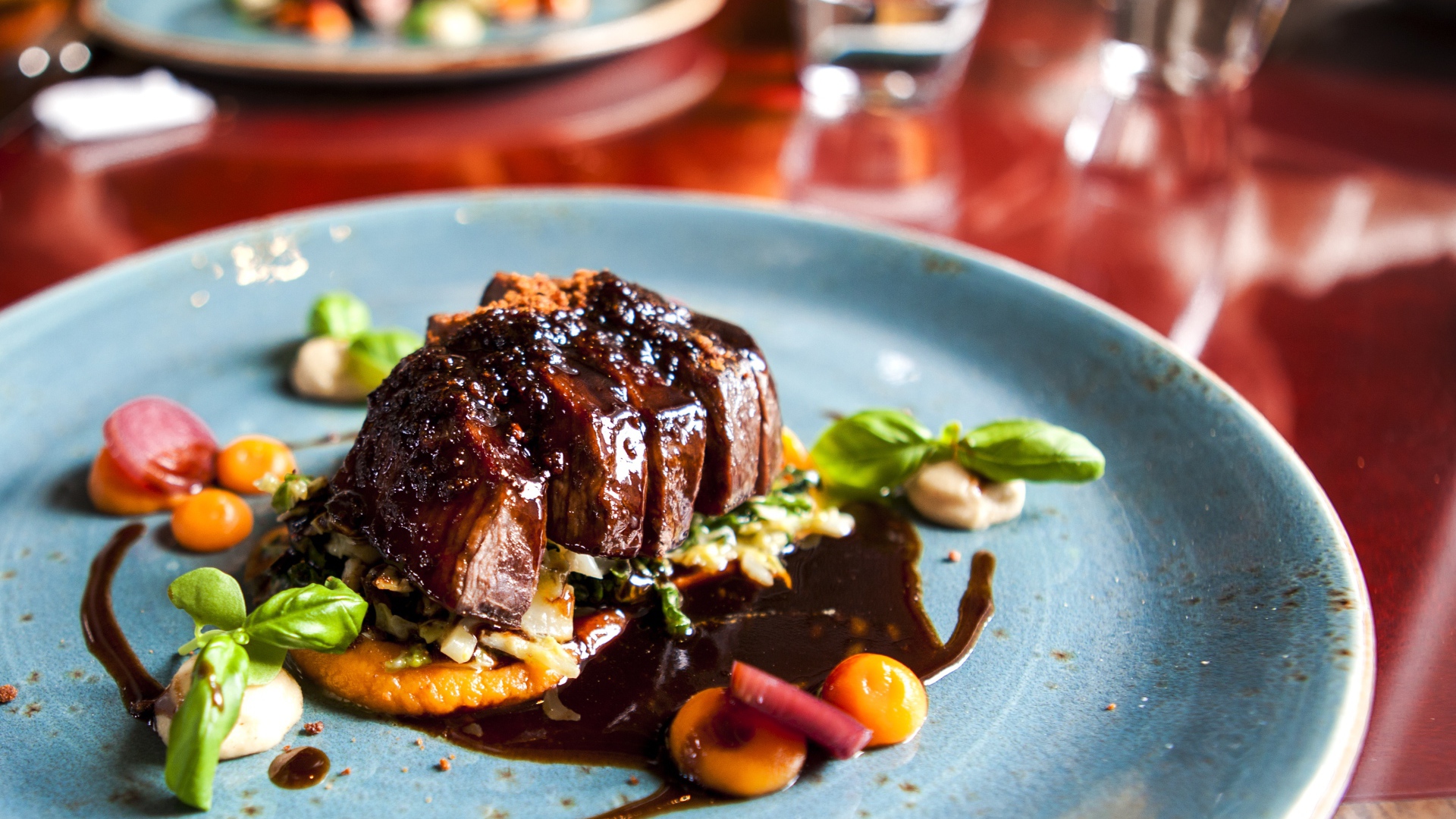 Кусок мяса с соусом на тарелке в ресторане