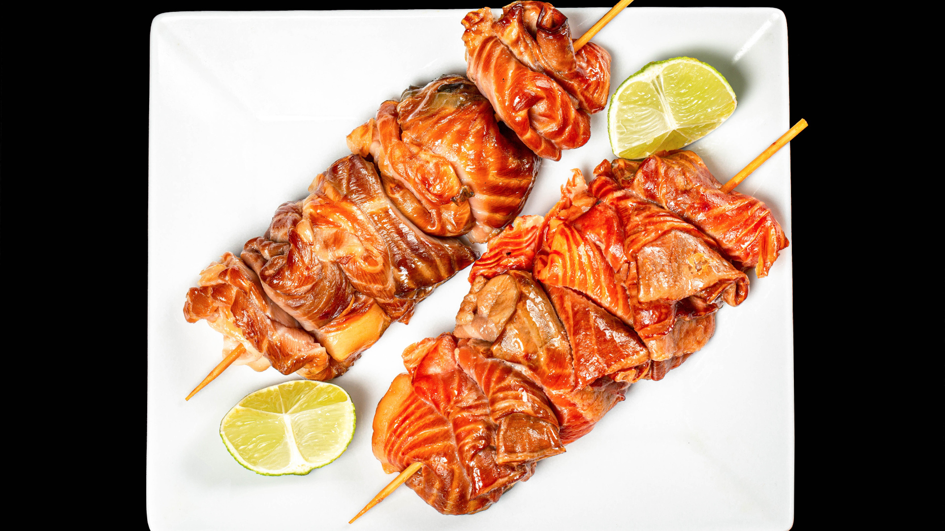 Шашлык на шпажках на белой тарелке с лимоном