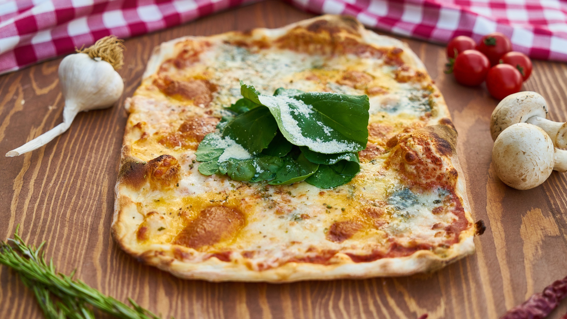 Румяная пицца на столе с овощами