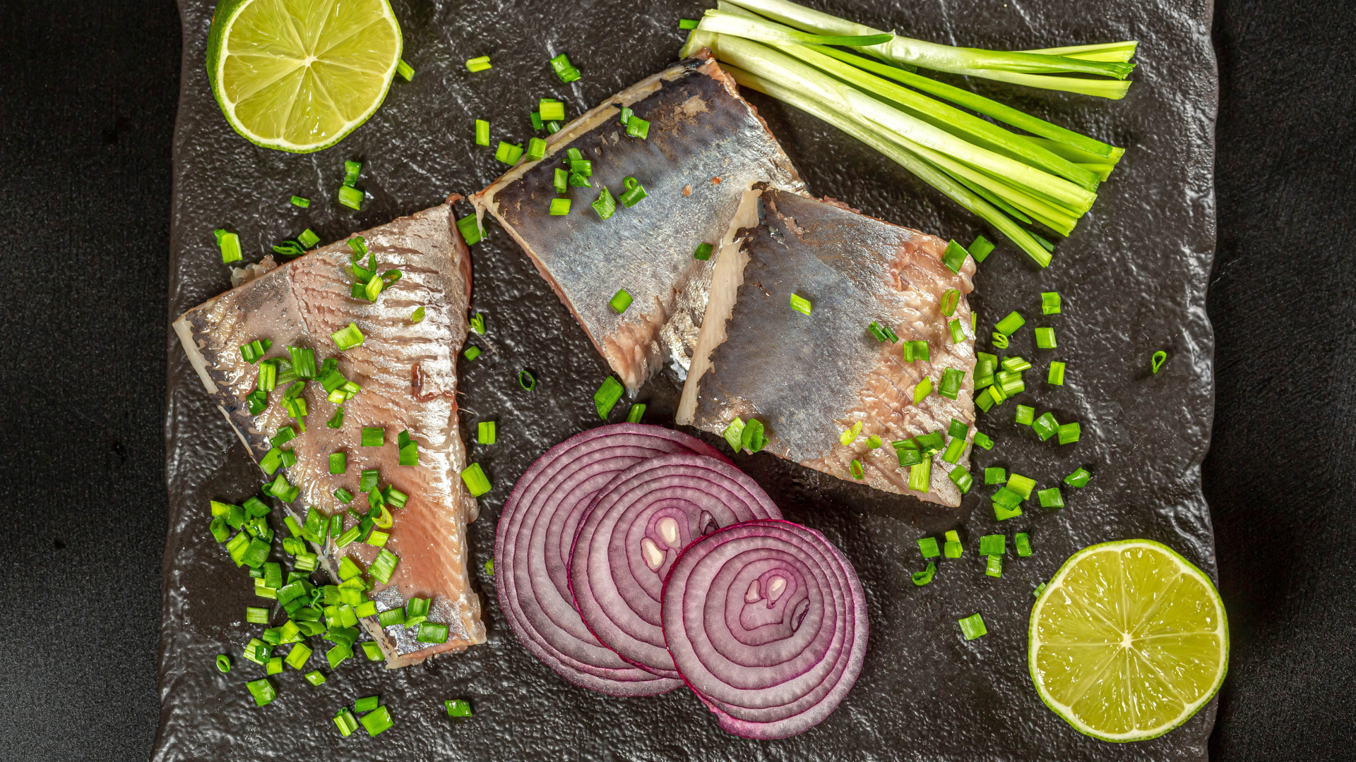 Куски сельди с луком и кусочками лимона