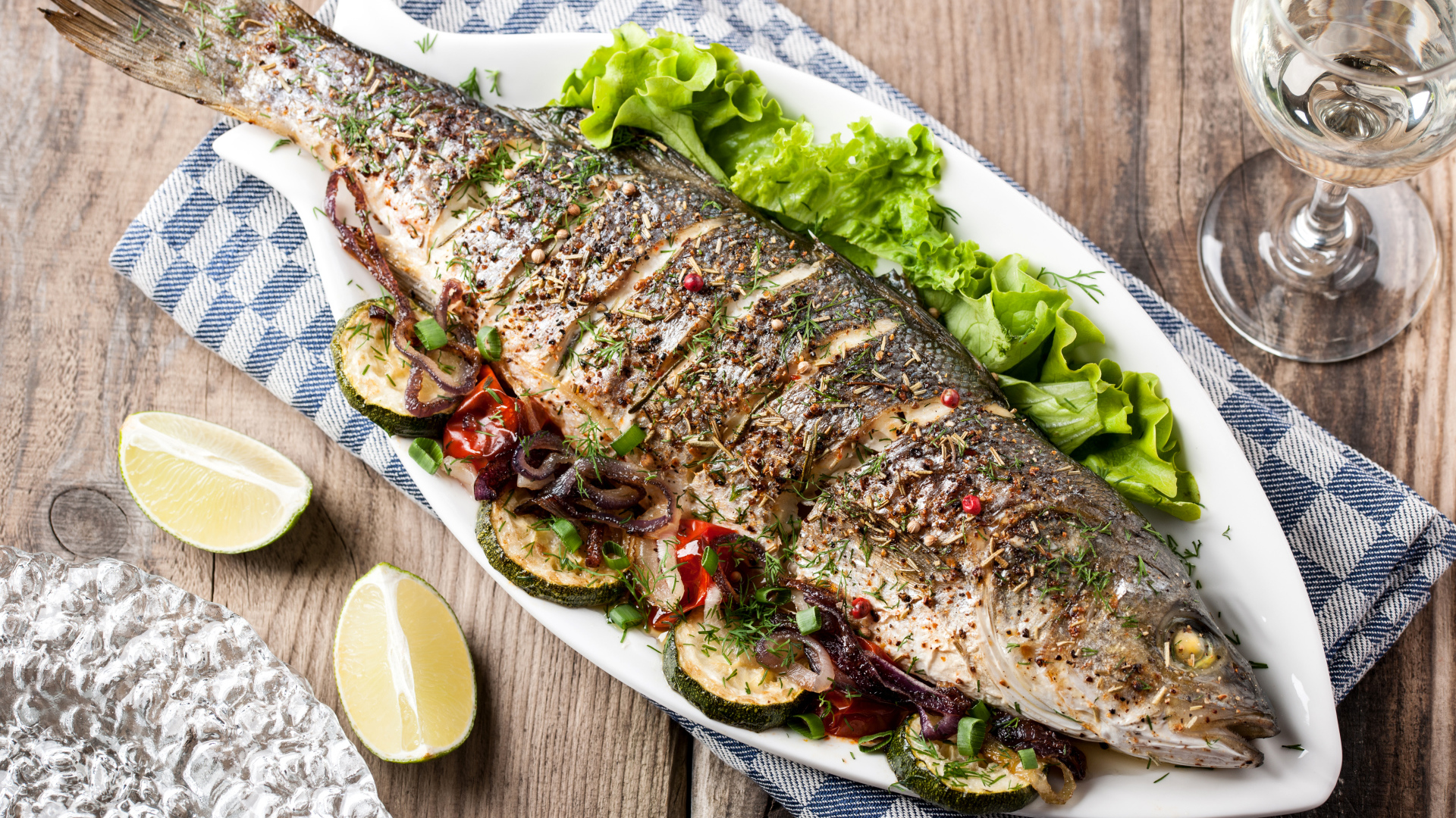 Большая запеченная рыба с кабачками и листьями салата