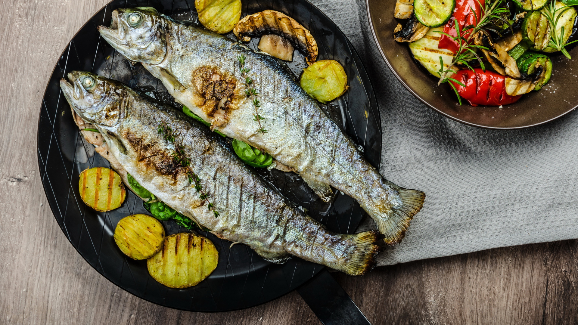 Две рыбины на сковороде с овощами