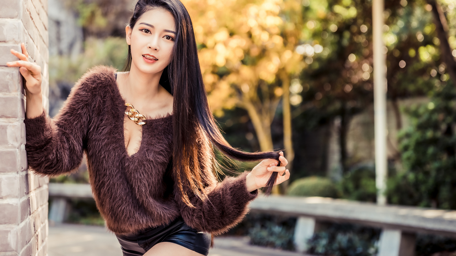 Девушка азиатка в черных шортах у стены