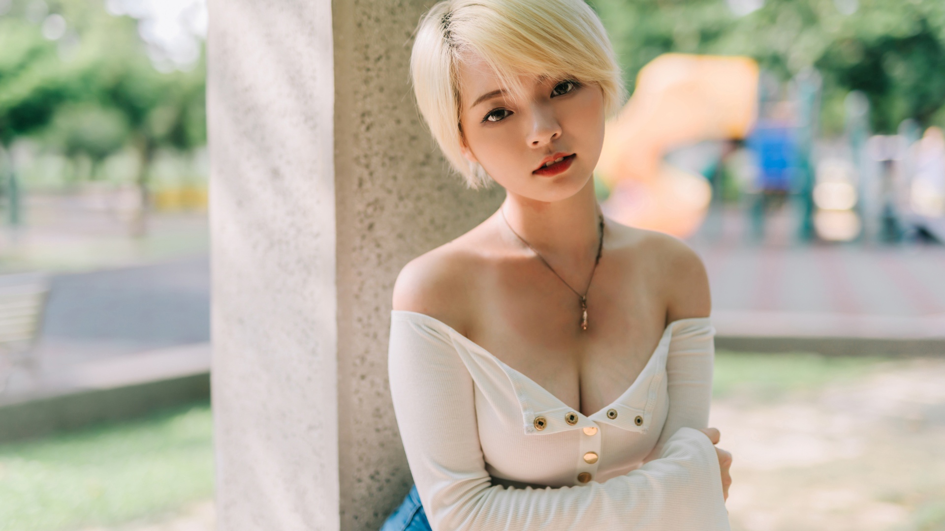 Девушка азиатка с короткой стрижкой у стены 