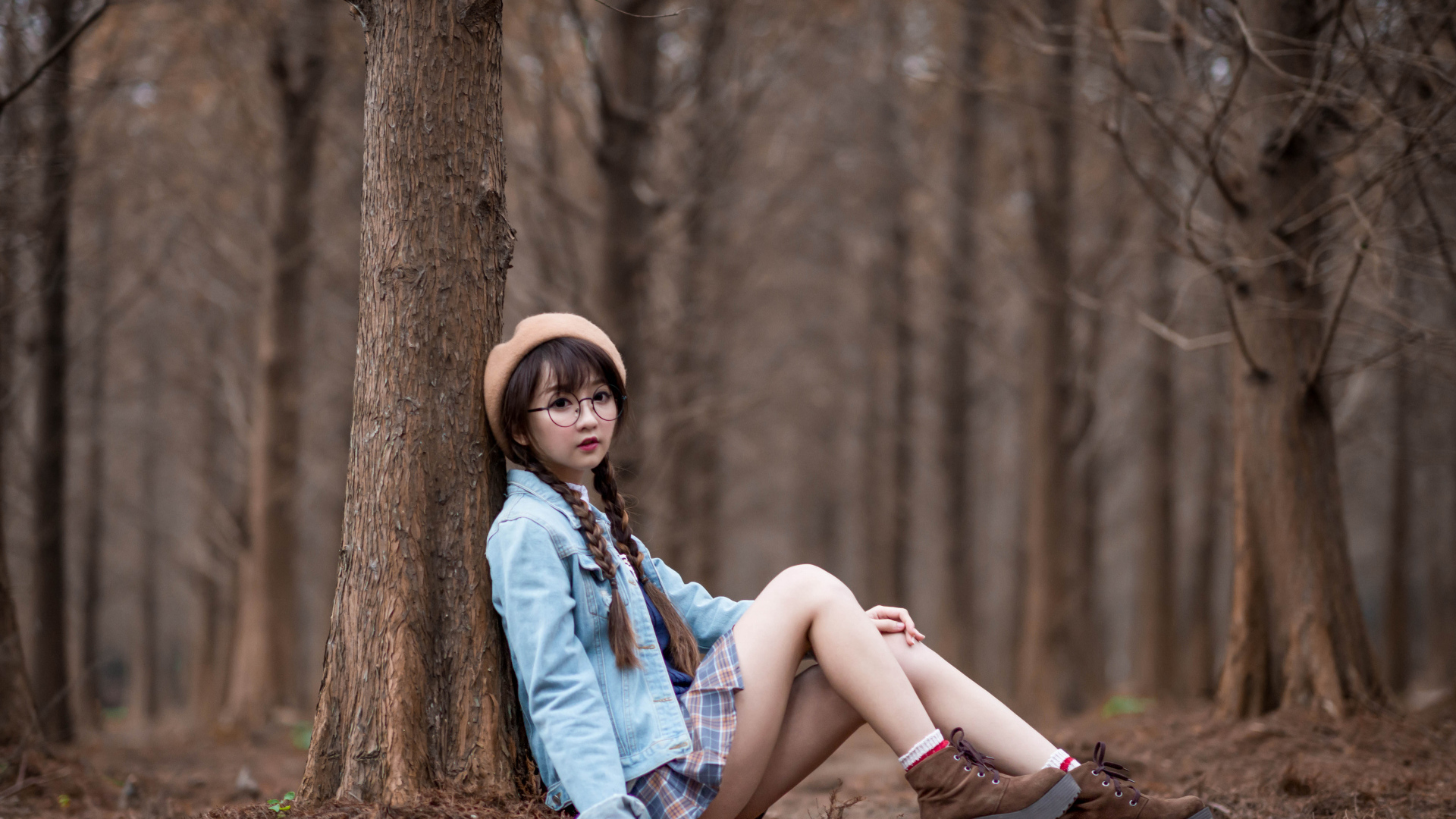 Девушка азиатка школьница сидит под деревом