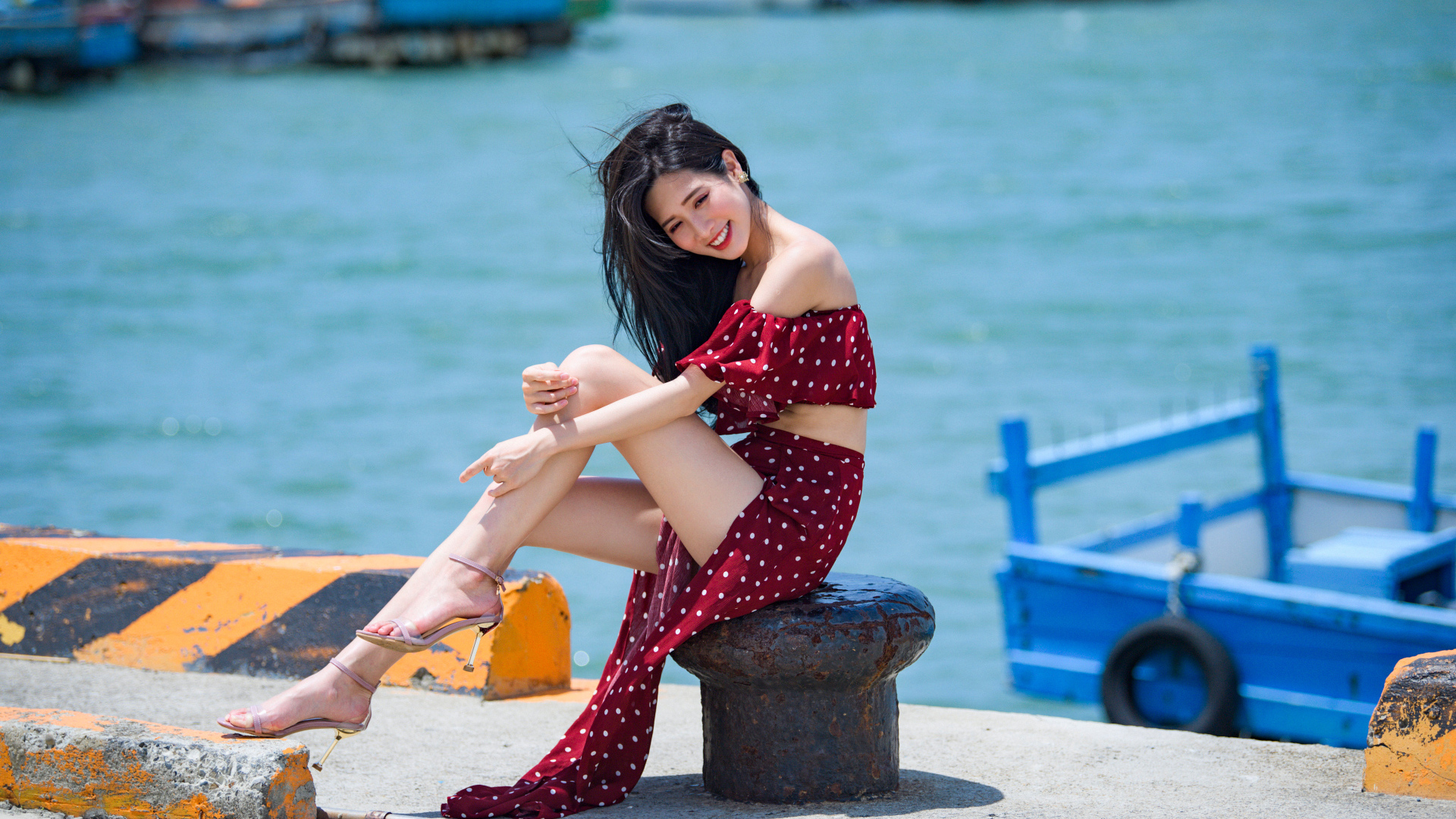 Красивая девушка азиатка в платье в горох у моря