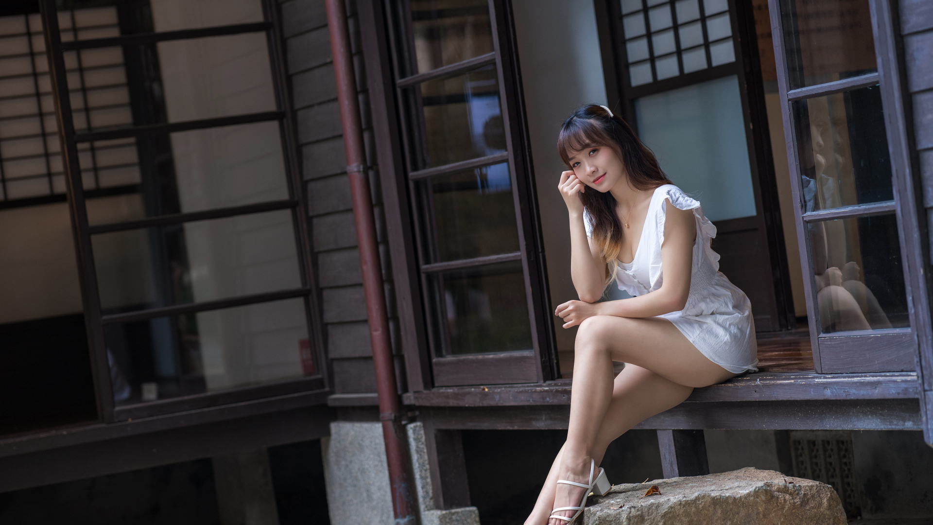 Красивая девушка азиатка сидит у двери