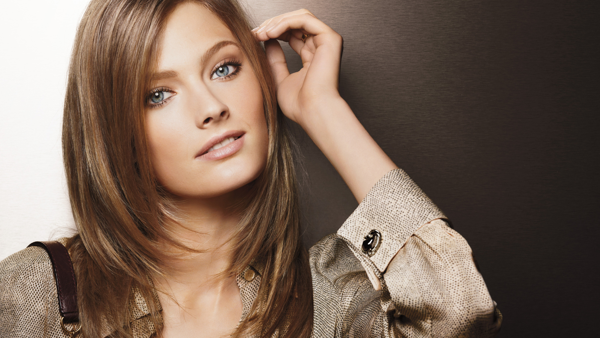 Beautiful blue-eyed girl in a shirt on a brown background