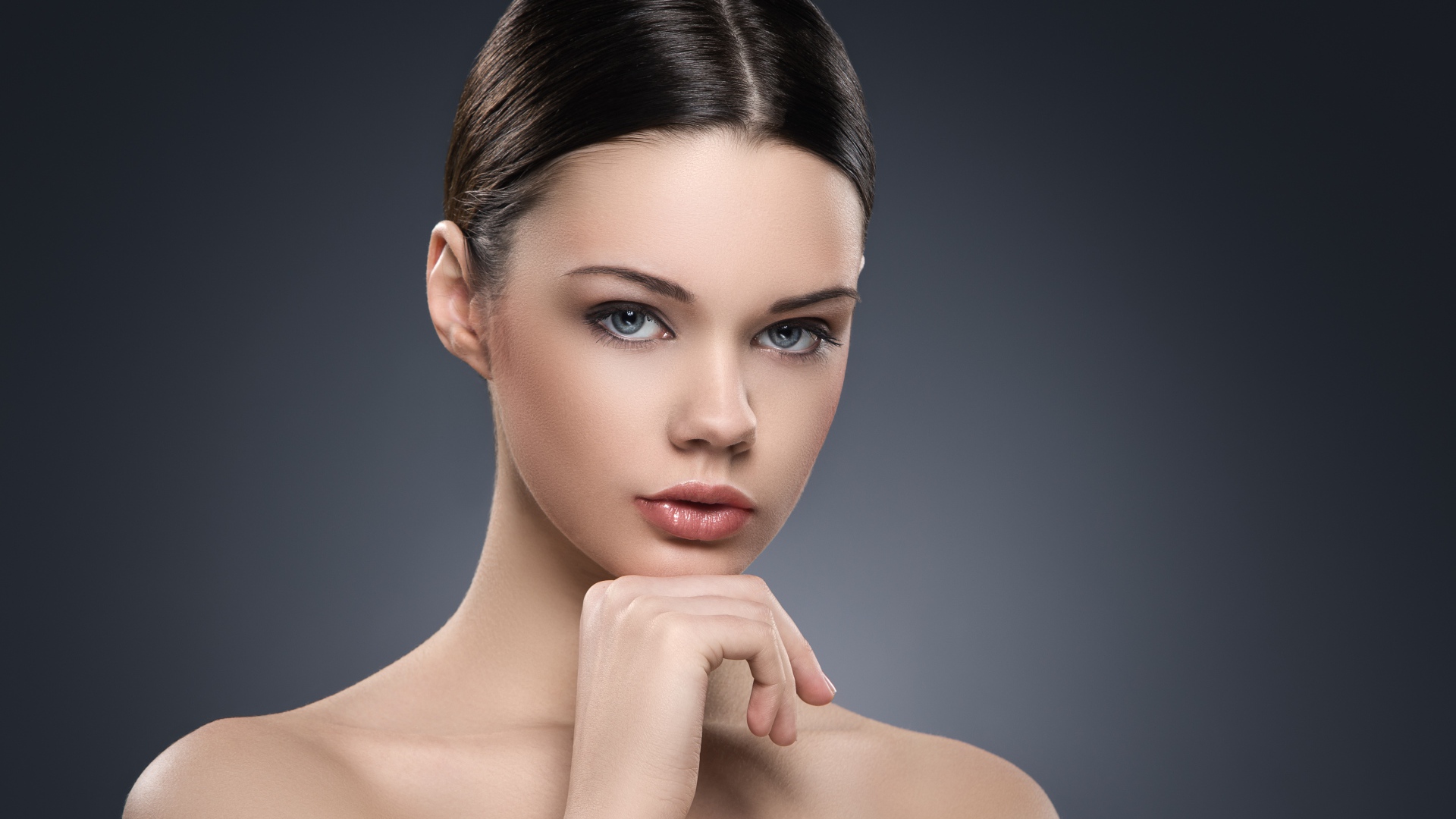 Красивая голубоглазая девушка на сером фоне 