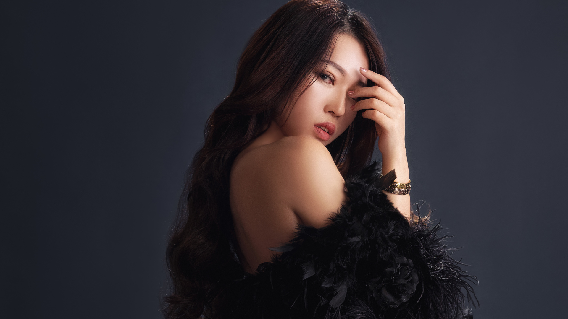 Красивая девушка в черном манто на сером фоне