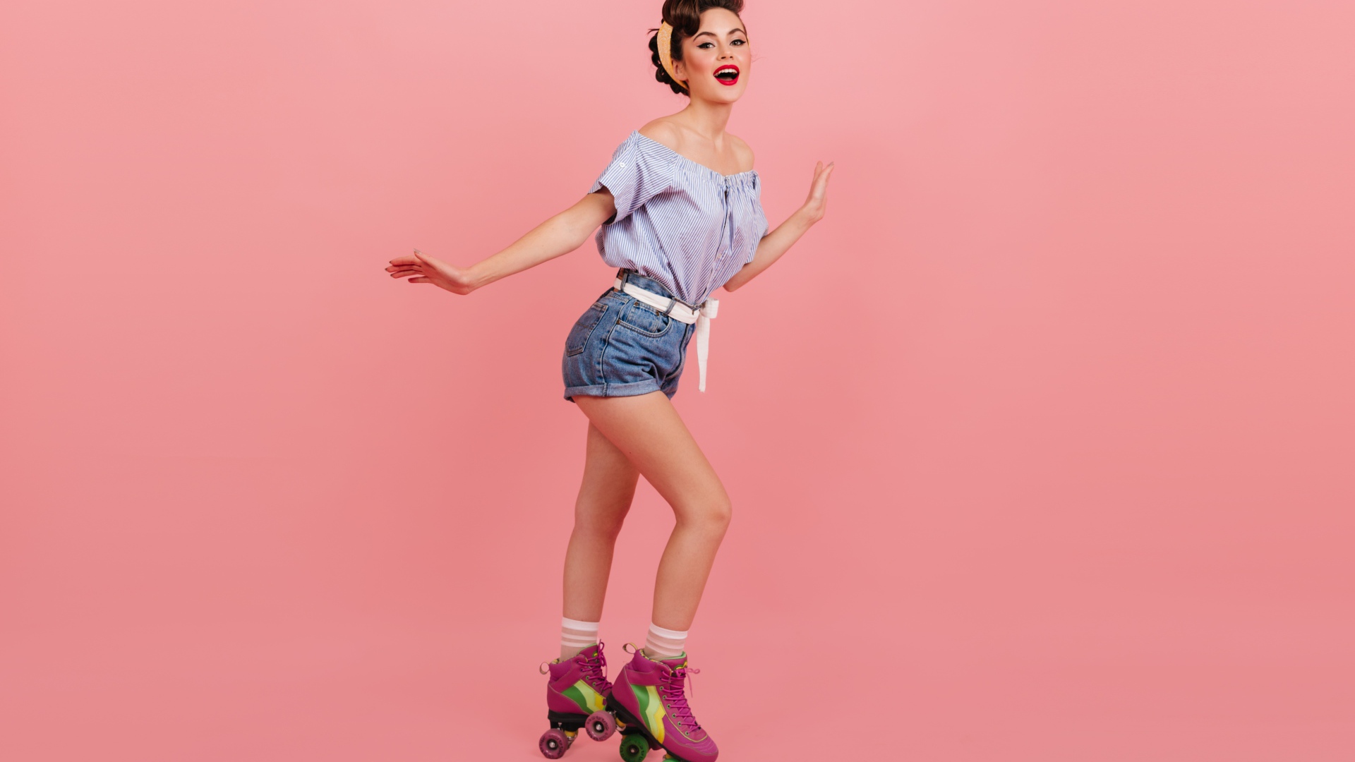 Красивая девушка на роликах на розовом фоне 
