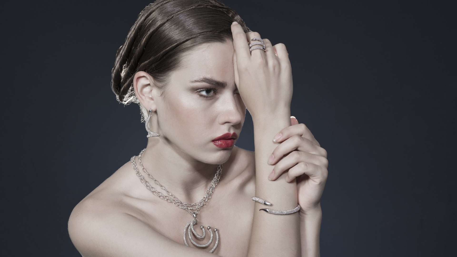 Красивая девушка с украшениями на теле на сером фоне