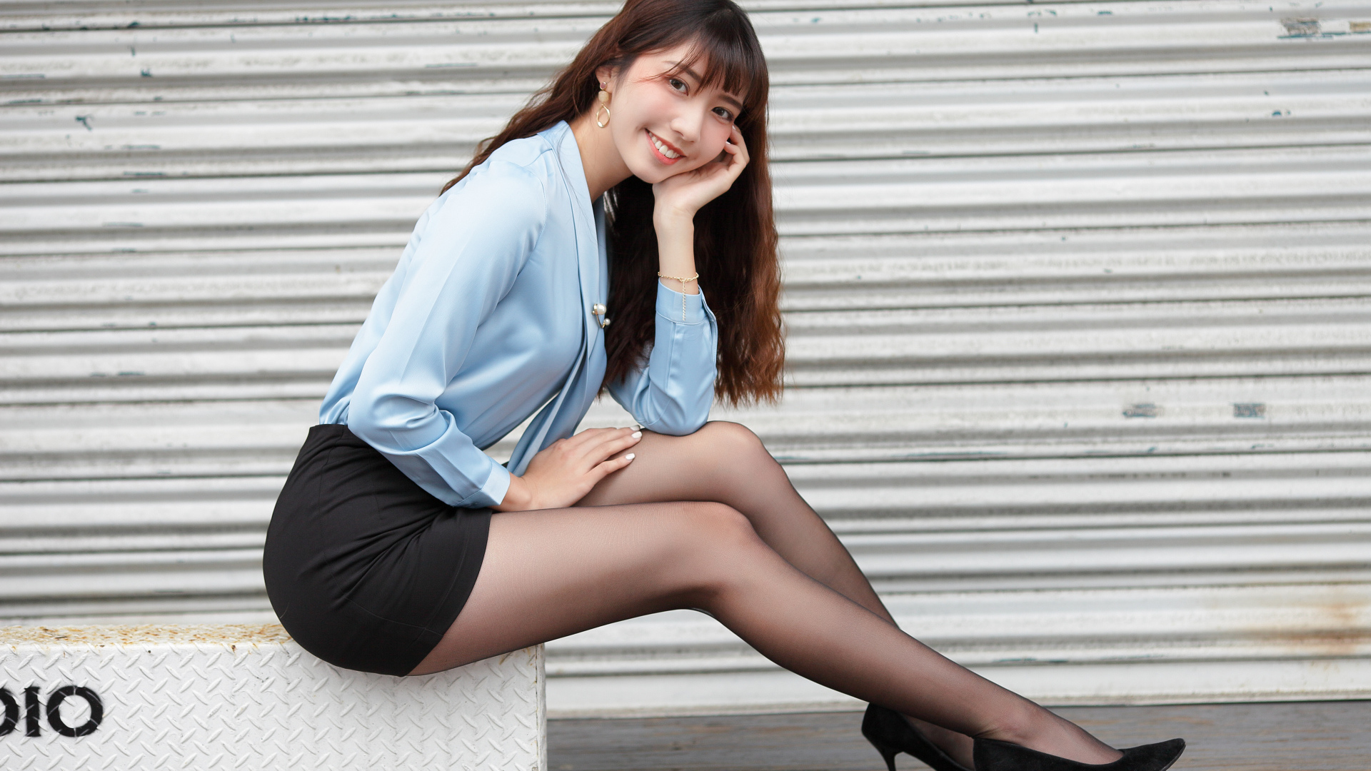 Красивая улыбающаяся девушка азиатка в черной юбке 