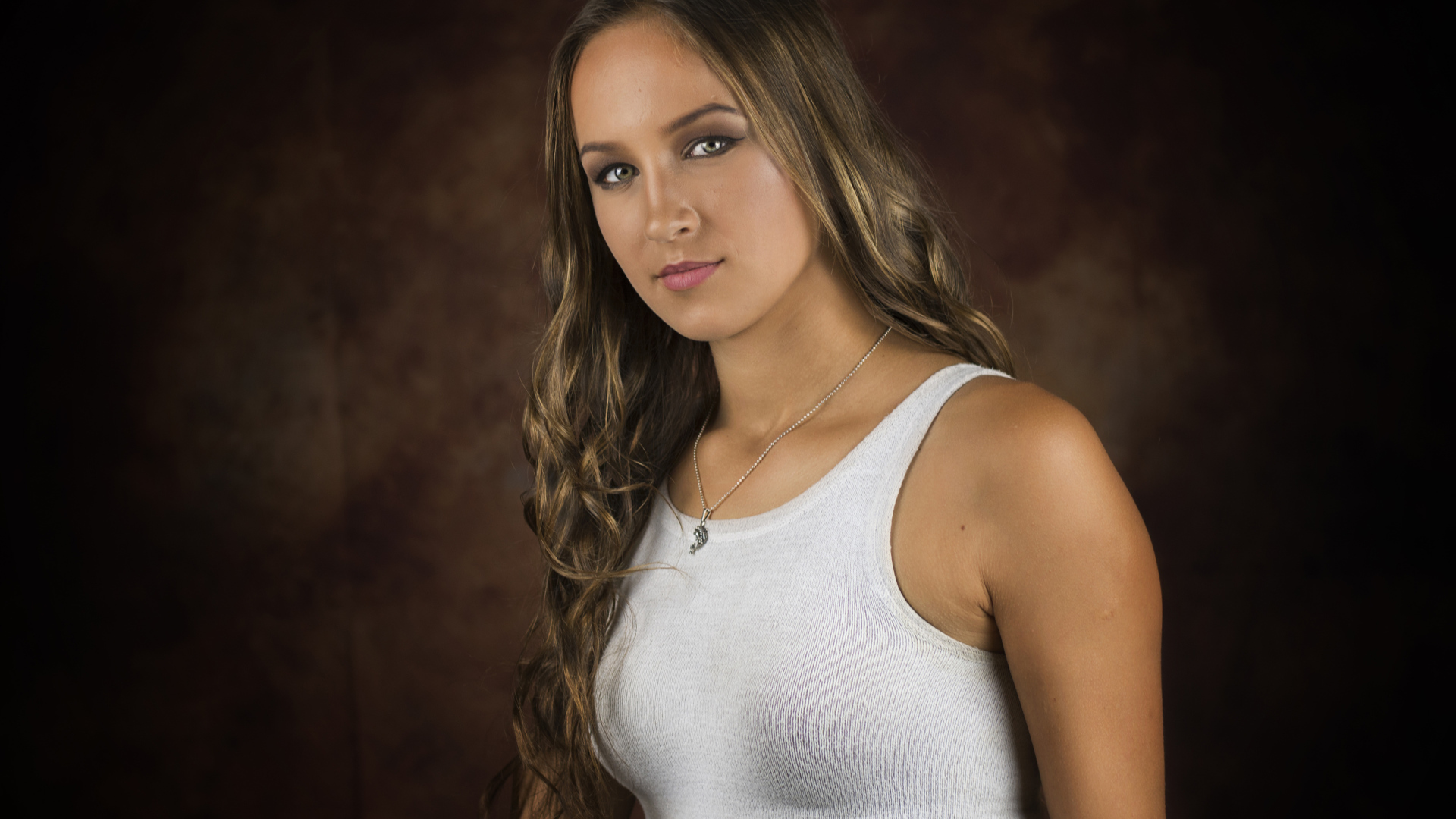 Красивая молодая девушка с длинными волосами в белой майке 