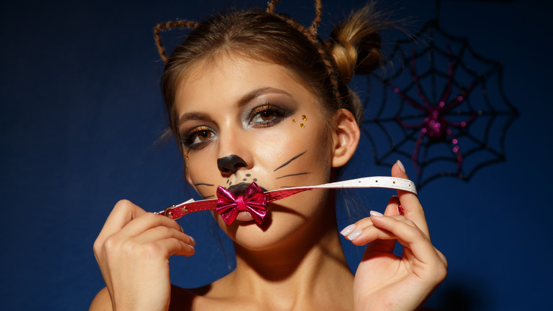 Девушка кошка с красным бантиком во рту 