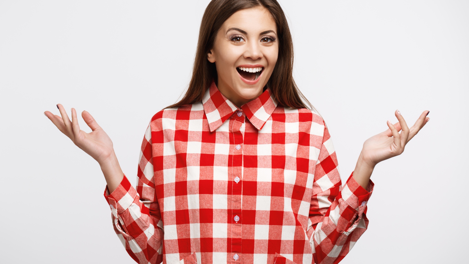 Cheerful girl in a plaid shirt on a white background