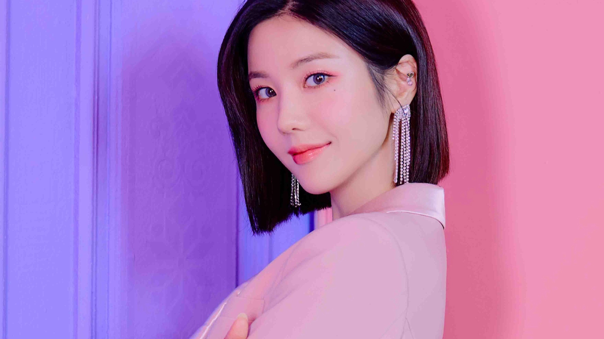 Милая девушка азиатка с короткой стрижкой на розовом фоне 