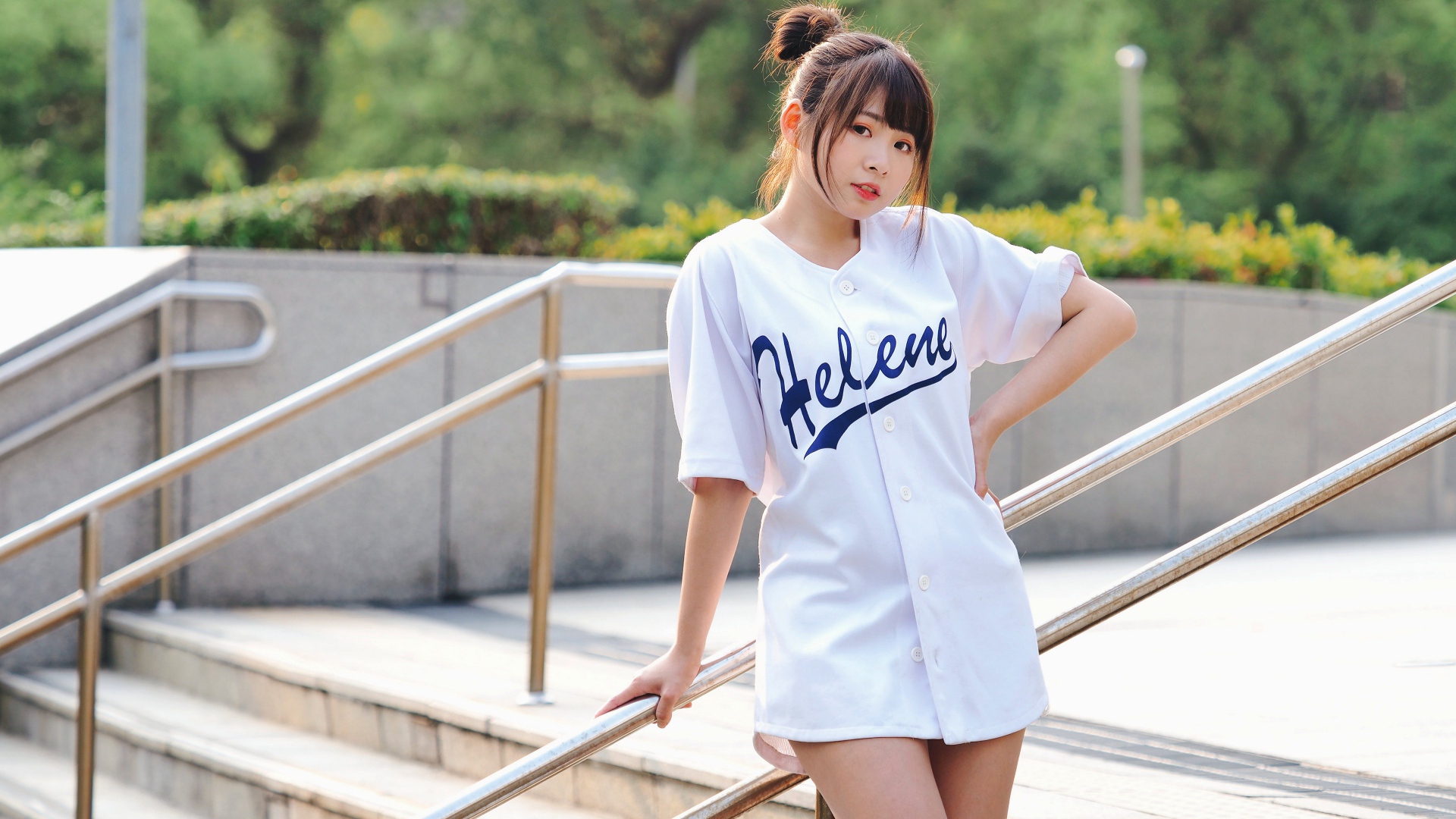 Симпатичная молодая азиатка стоит у перил