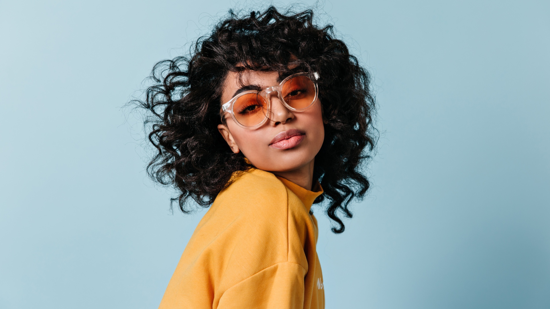 Темнокожая девушка в очках на голубом фоне фоне