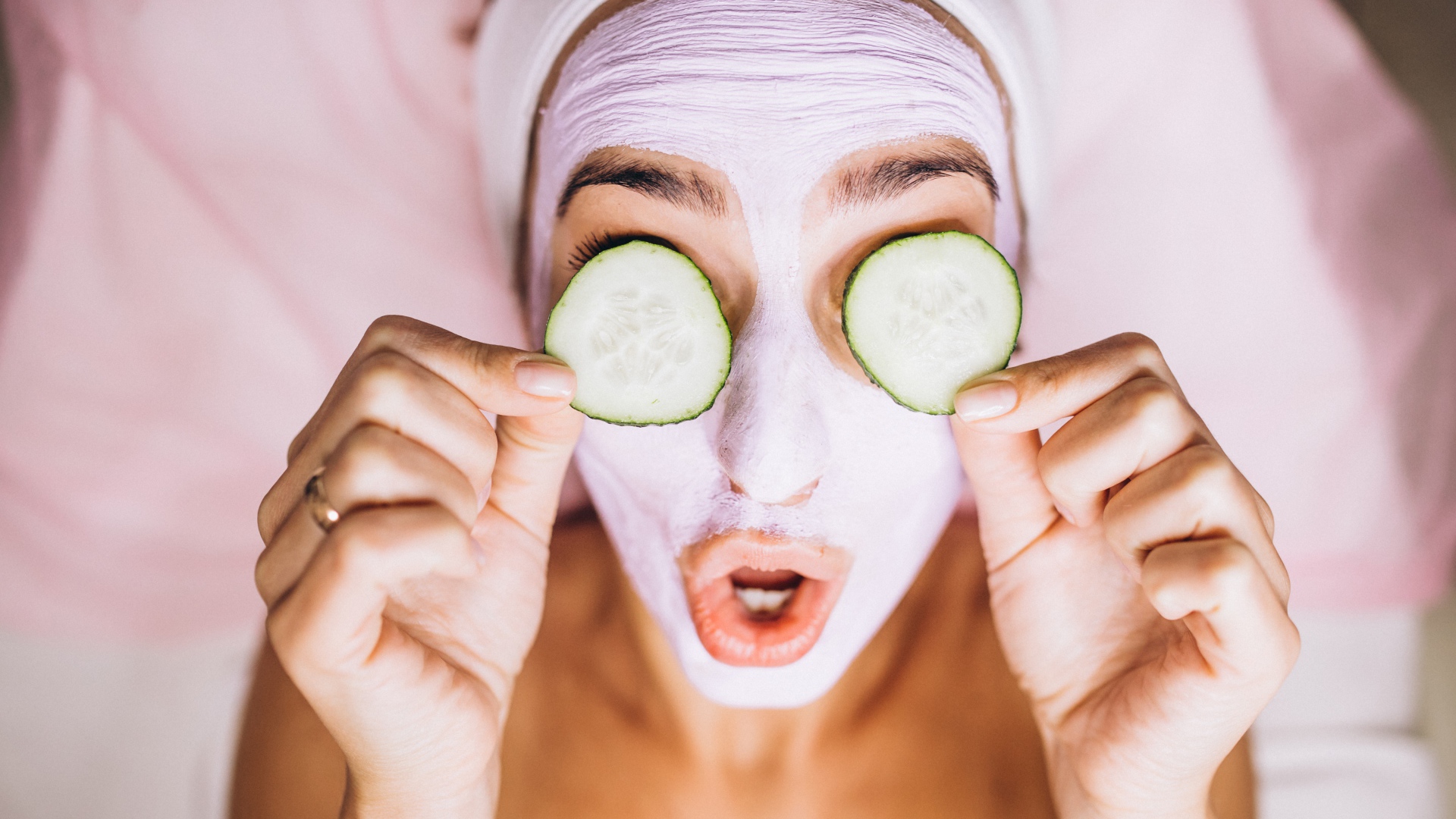 Девушка с маской на лице с огурцами на глазах 