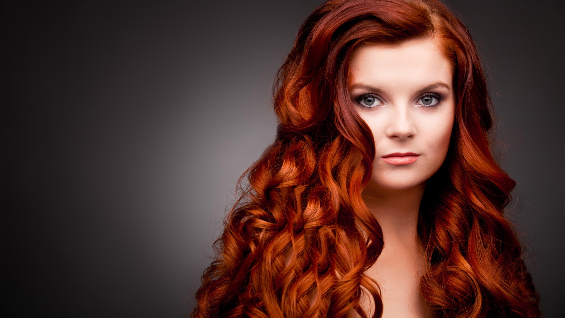 Длинные ярко рыжие волосы у красивой девушки 