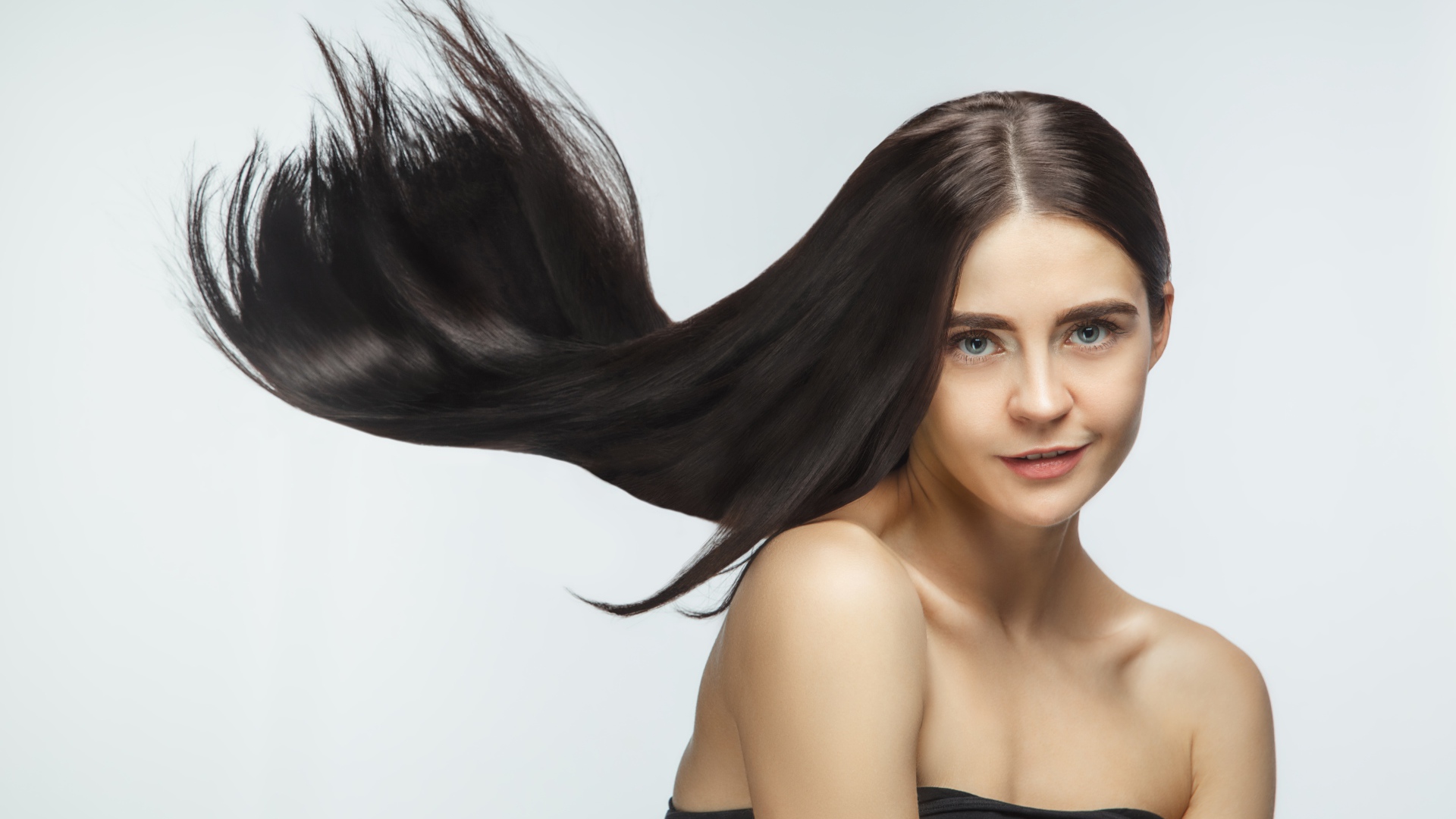 Длинные шелковистые волосы молодой брюнетки 