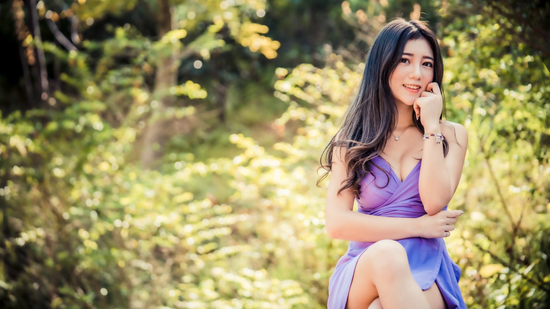 Улыбающаяся девушка азиатка в сиреневом платье