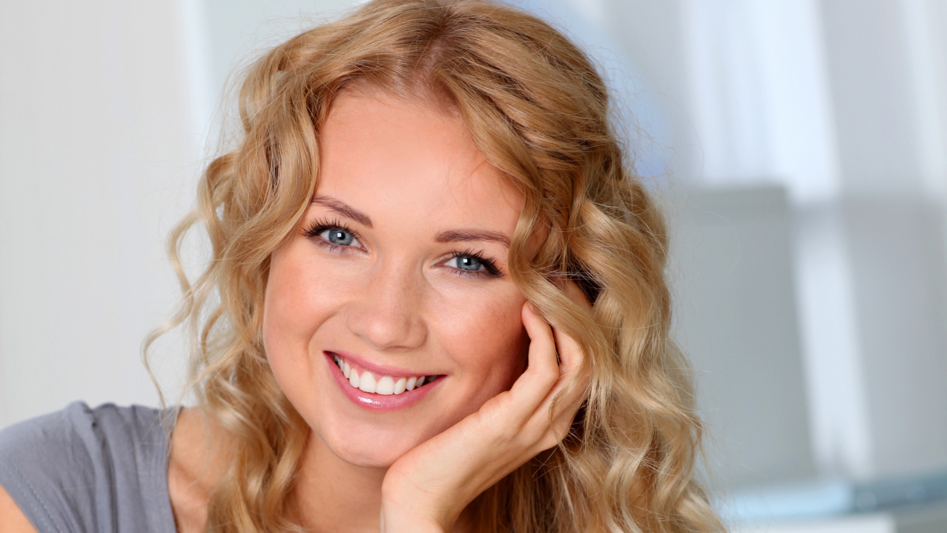 Улыбающаяся девушка в голубыми глазами 