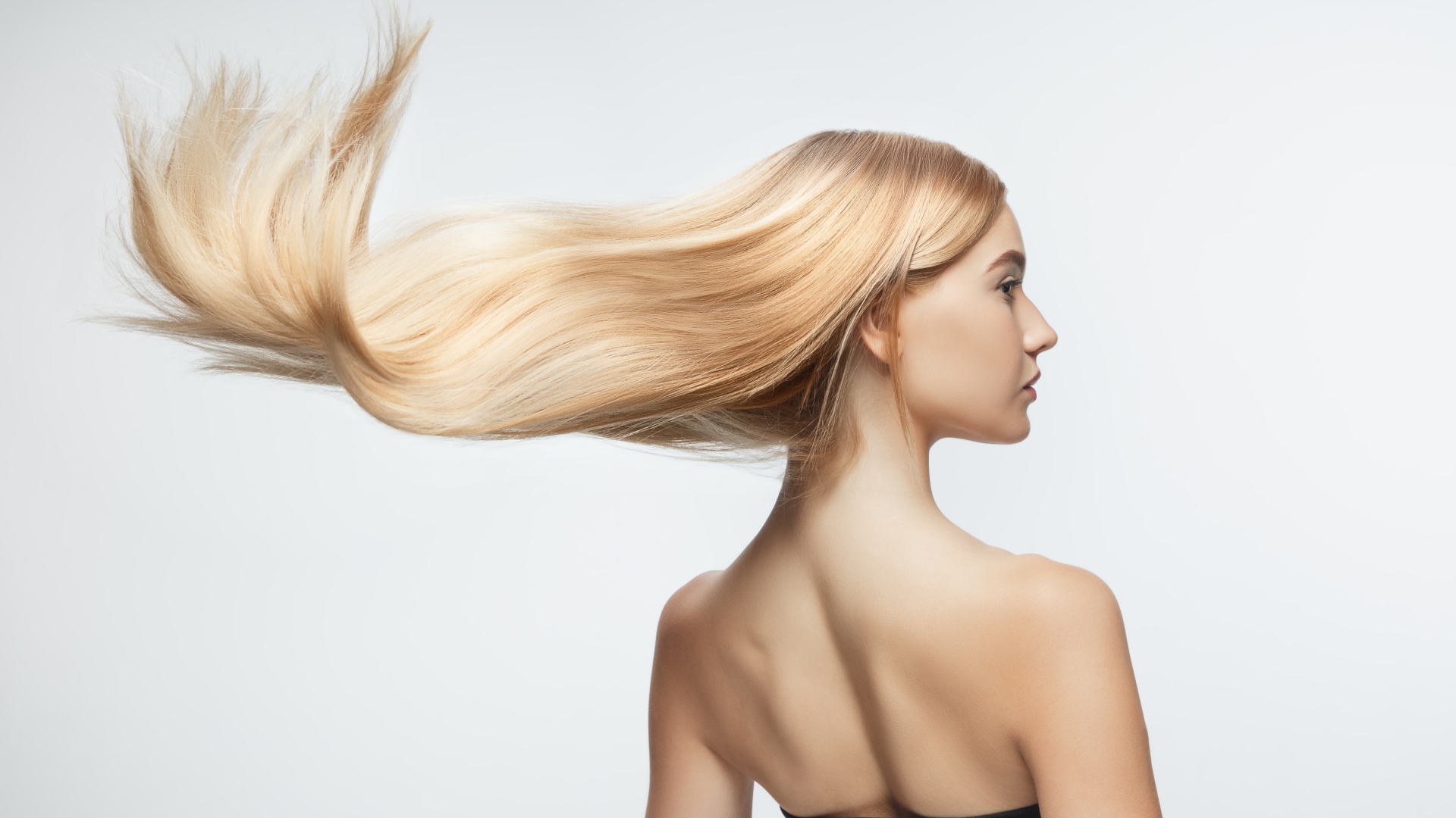 Белые волосы девушки развиваются на белом фоне 